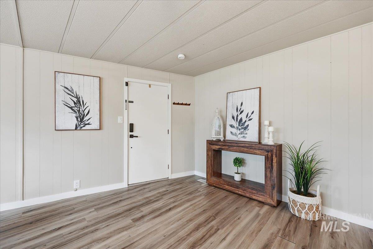 Entrance foyer with wood finished floors and wood walls