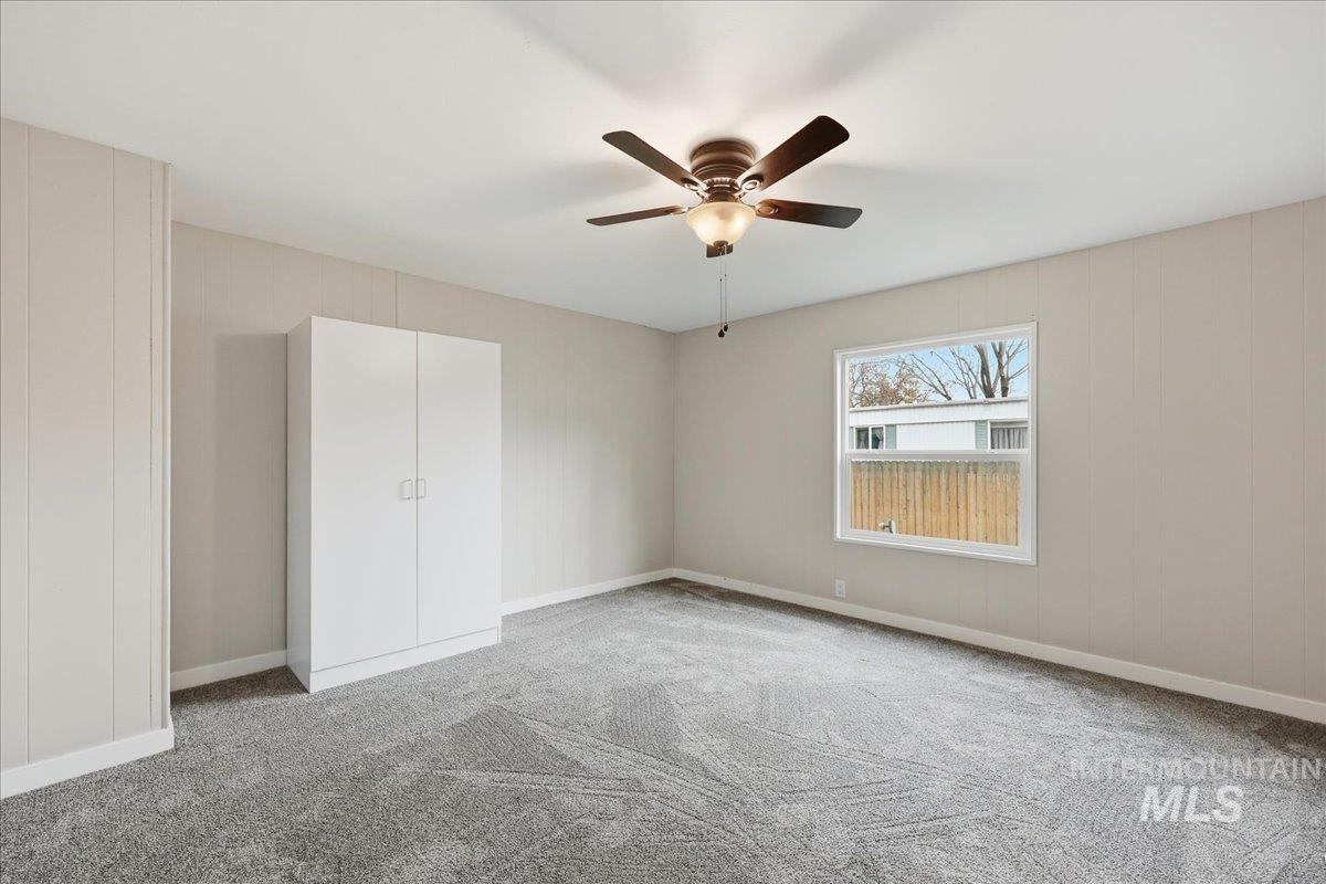 Unfurnished bedroom with light carpet and a ceiling fan