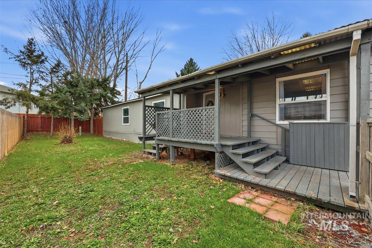 Rear view of house with a wooden deck and a fenced backyard