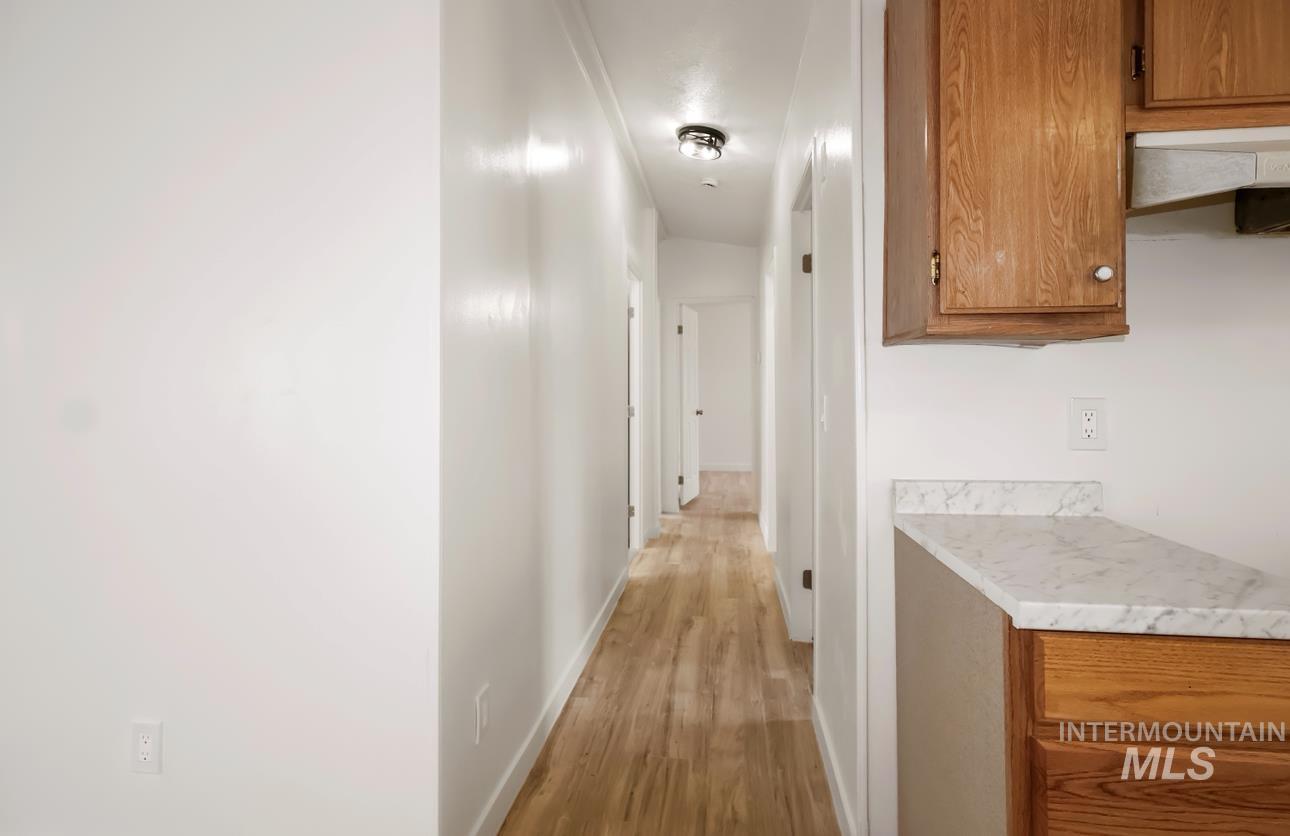 Hallway featuring light wood-style floors and baseboards