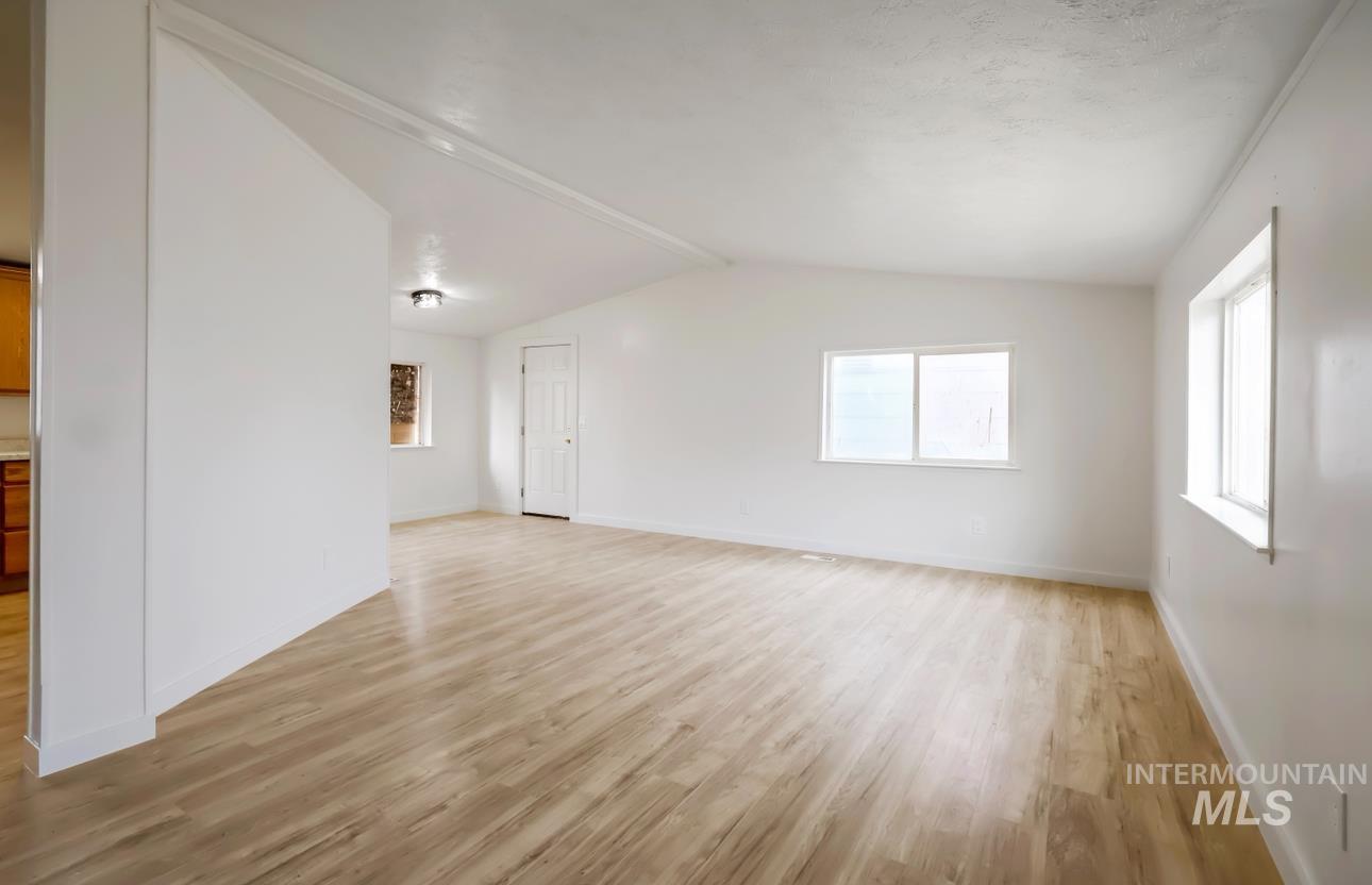 Spare room with light wood-type flooring and baseboards