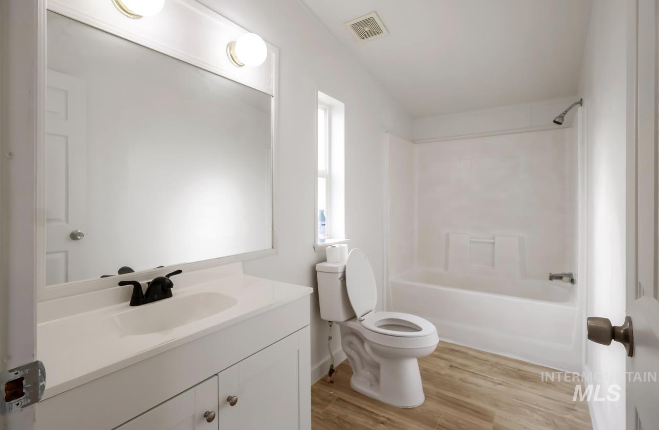 Full bath featuring vanity, shower / washtub combination, and light wood-style floors