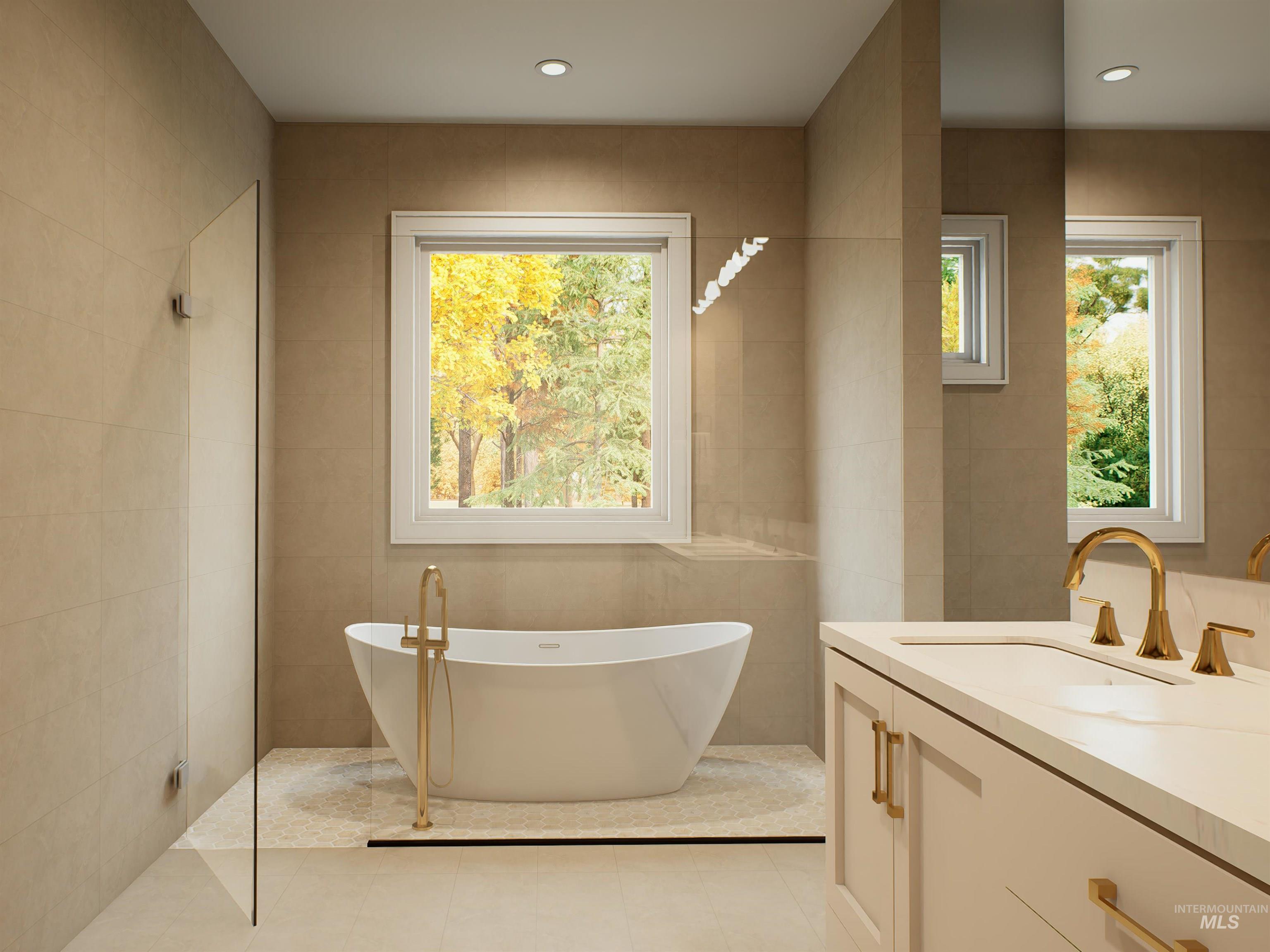 Full bathroom featuring tile walls, vanity, a freestanding tub, and recessed lighting