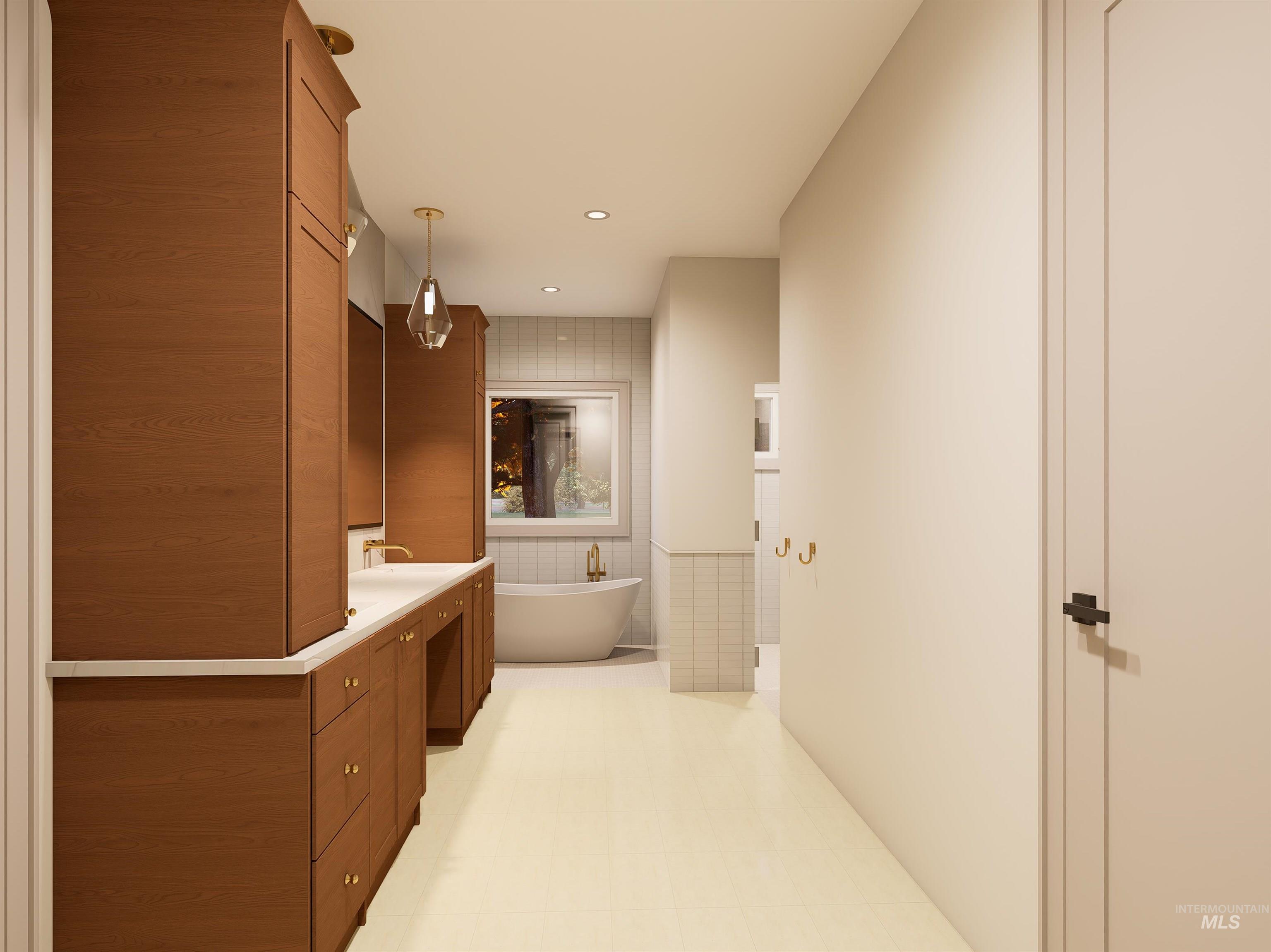 Full bath featuring vanity, tile walls, a freestanding bath, recessed lighting, and a wainscoted wall