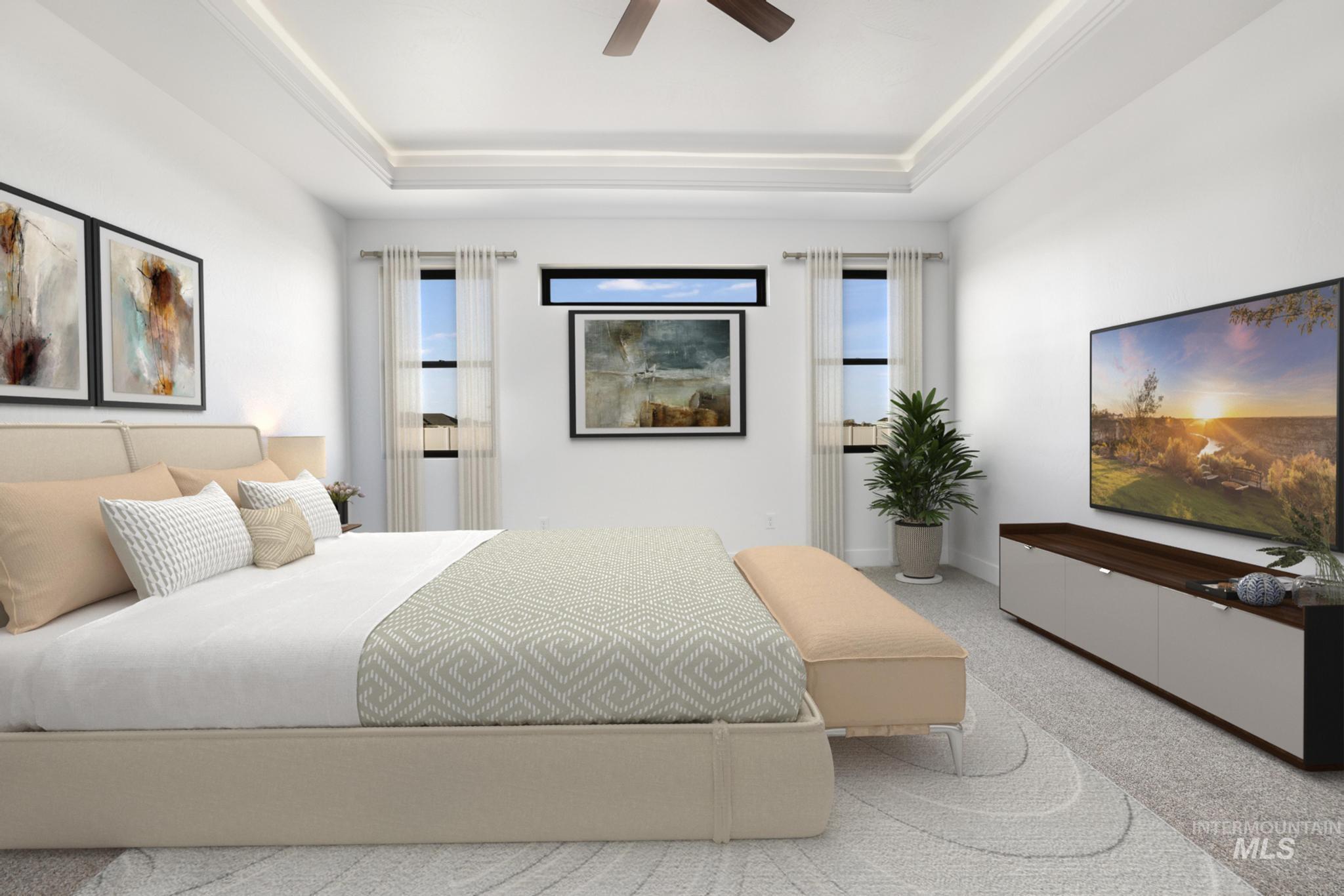 Bedroom with a ceiling fan, carpet floors, and a raised ceiling