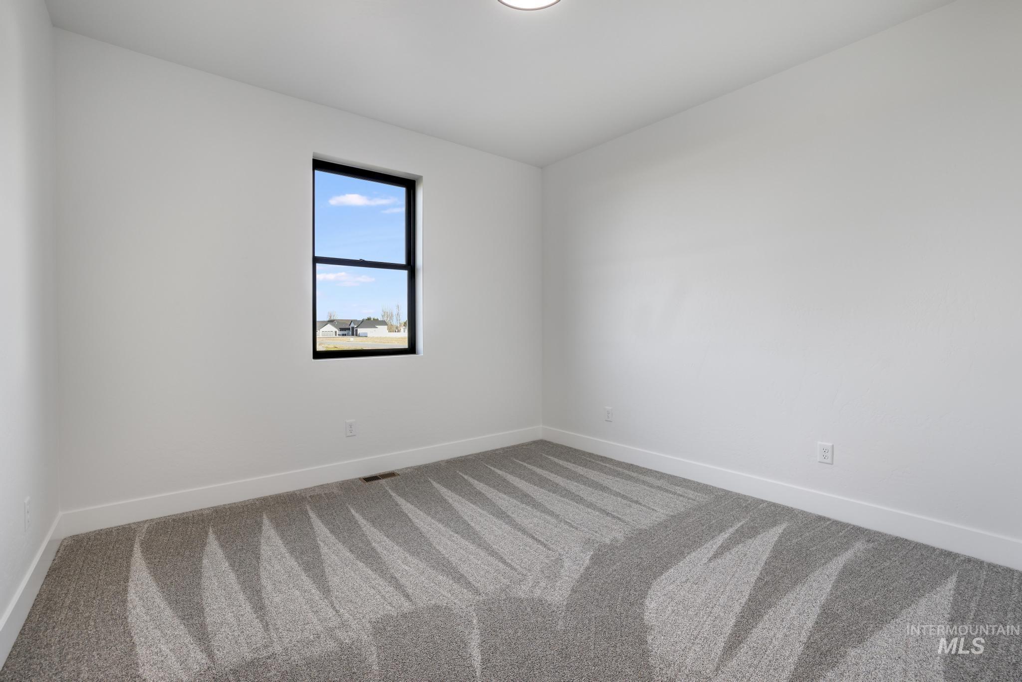 Carpeted empty room with baseboards