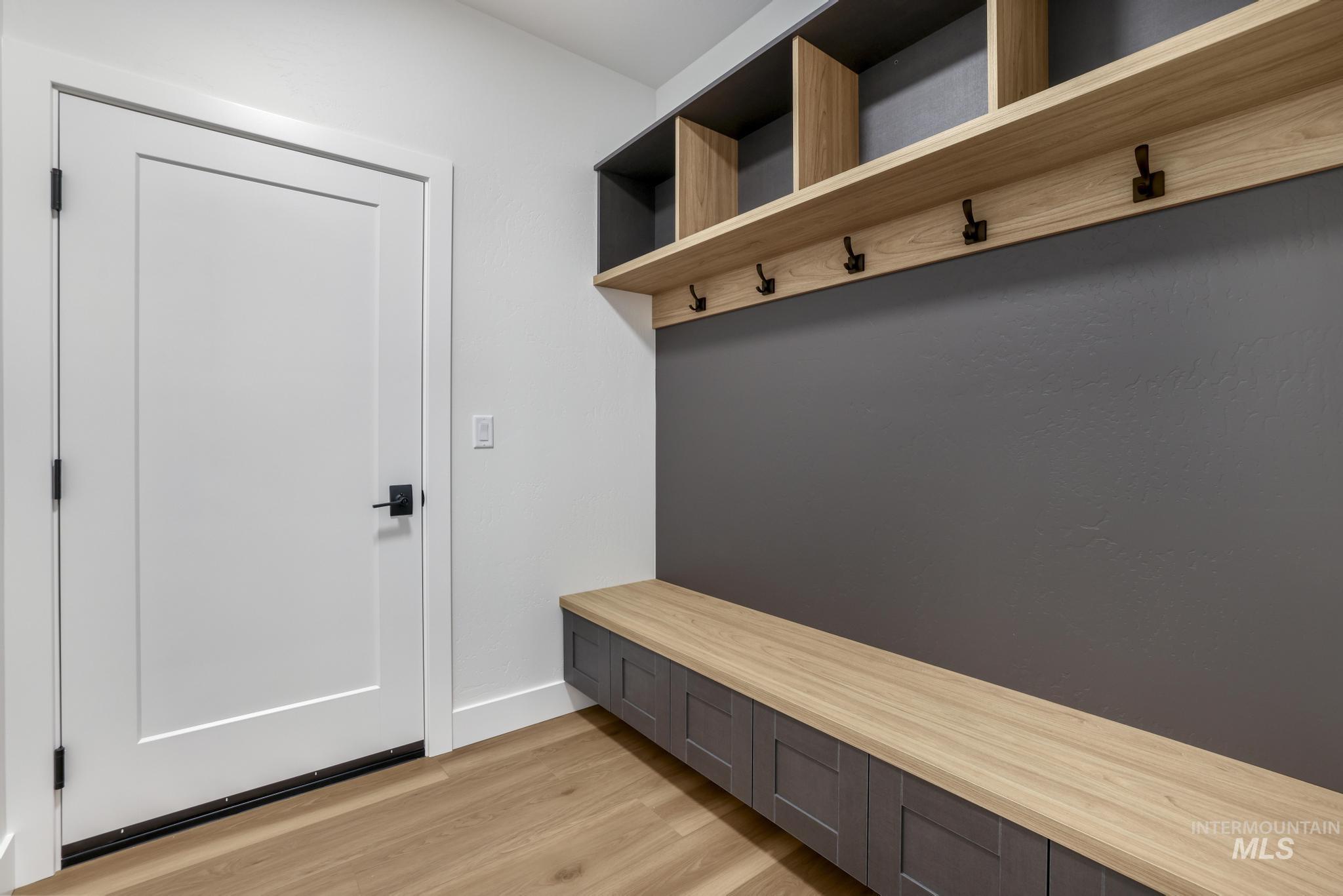 Mudroom with light wood-style floors and baseboards