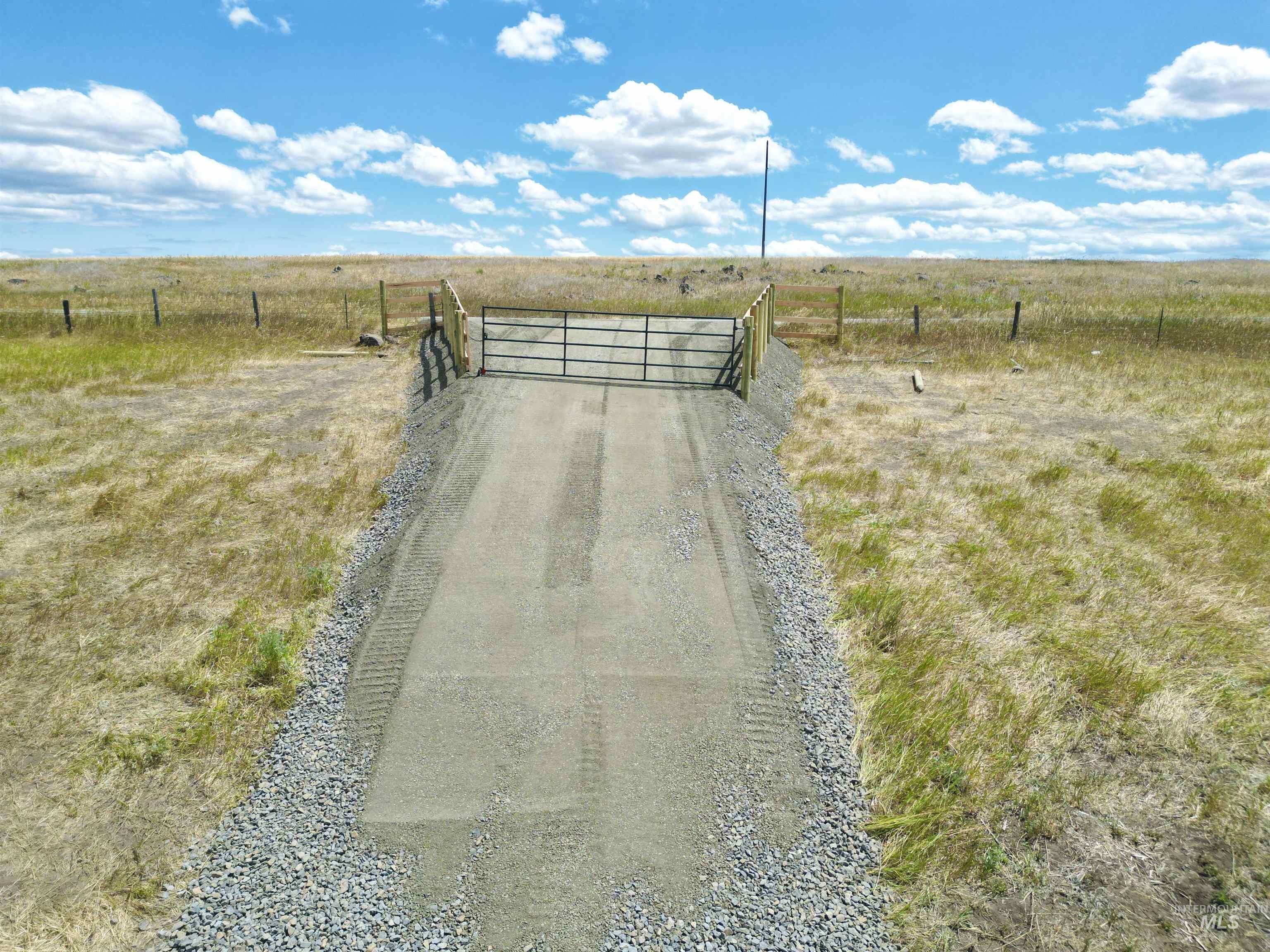 View of street with a view of rural / pastoral area and a gate