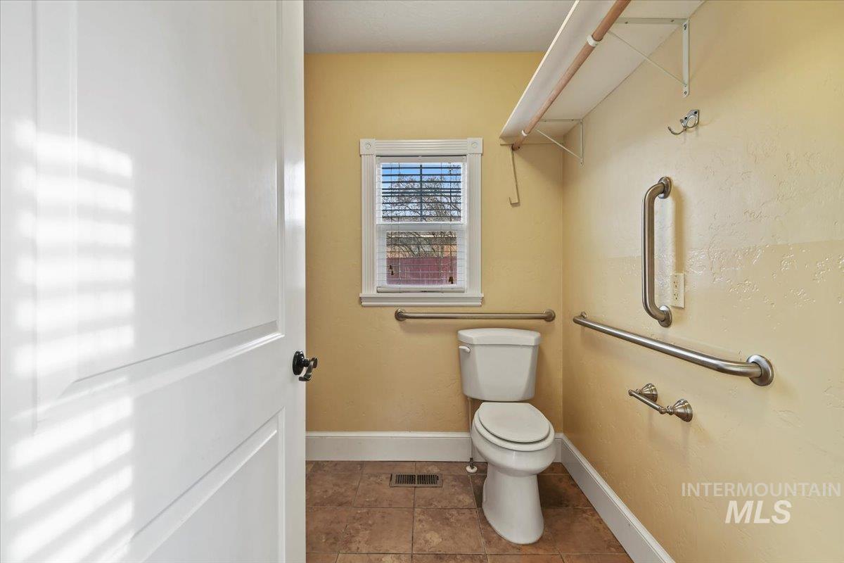 Bathroom with toilet and dark tile patterned floors