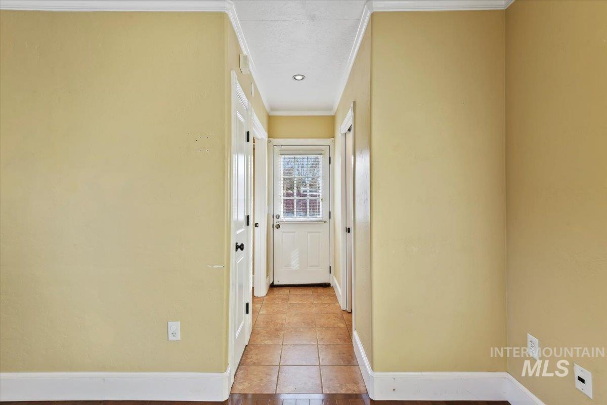 Hallway featuring crown molding and baseboards