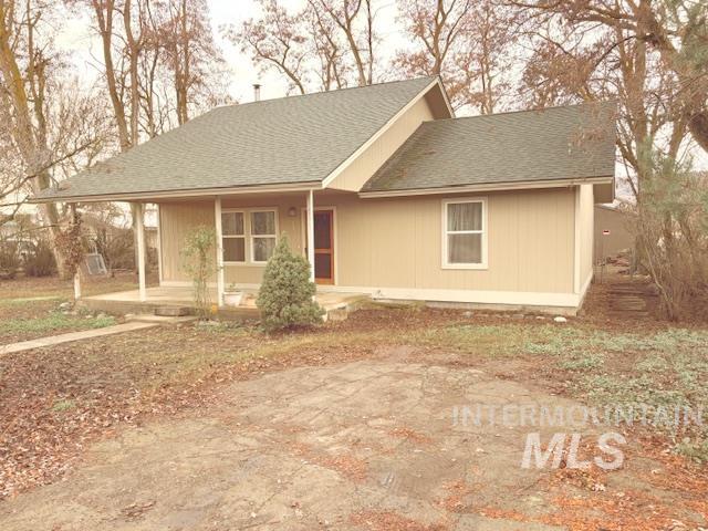 View of front of house featuring covered porch and a shingled roof