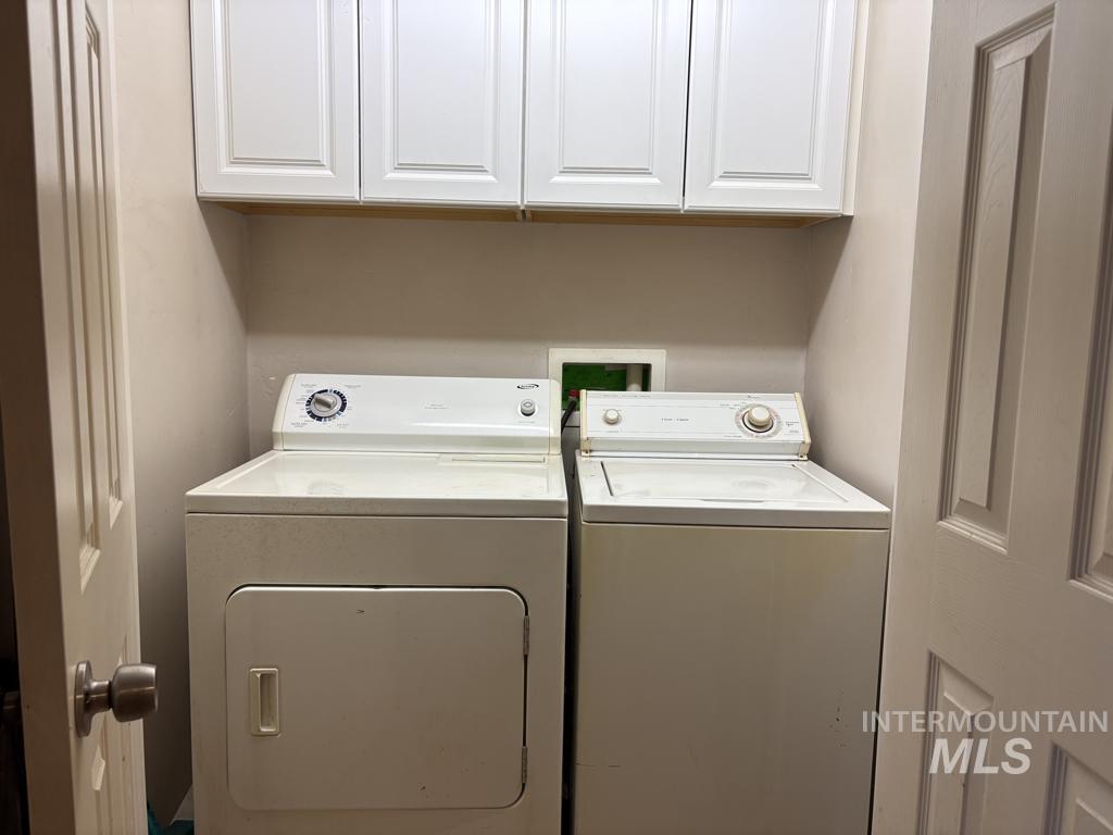 Laundry room featuring washing machine and clothes dryer and cabinet space