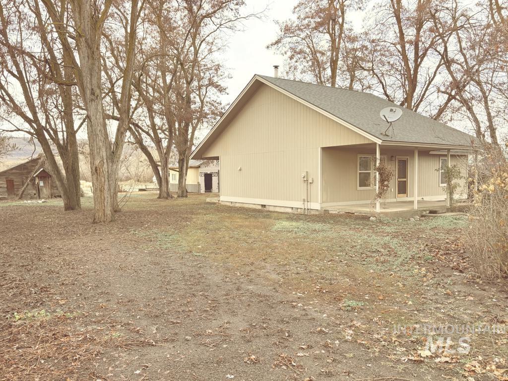 View of home's exterior featuring covered porch, a shingled roof, and crawl space