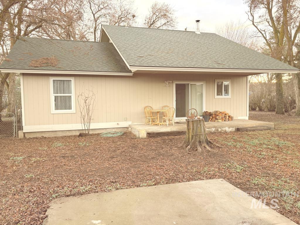 Back of house with roof with shingles and a patio