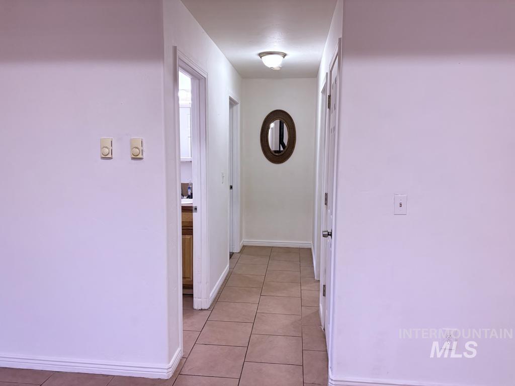 Hallway featuring baseboards and light tile patterned floors