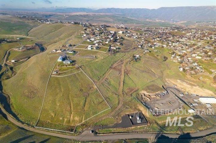 Aerial view of property and surrounding area with a mountain backdrop