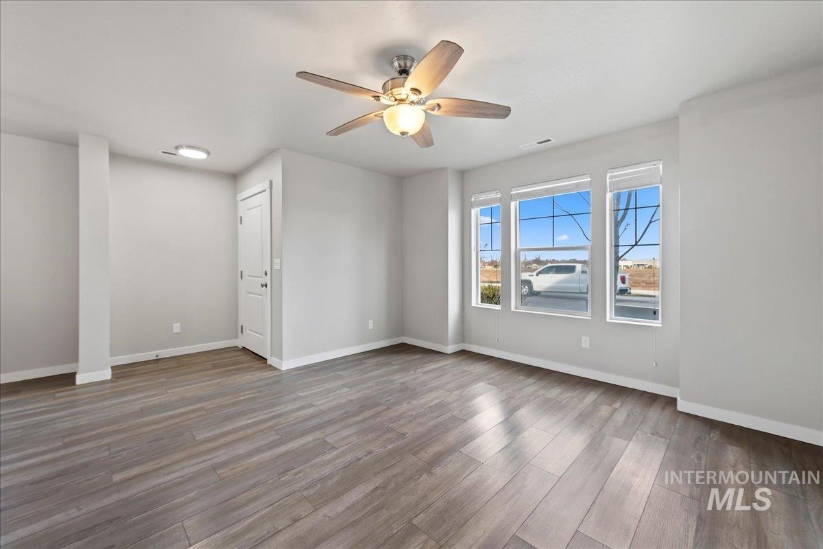 Empty room with light wood finished floors and ceiling fan