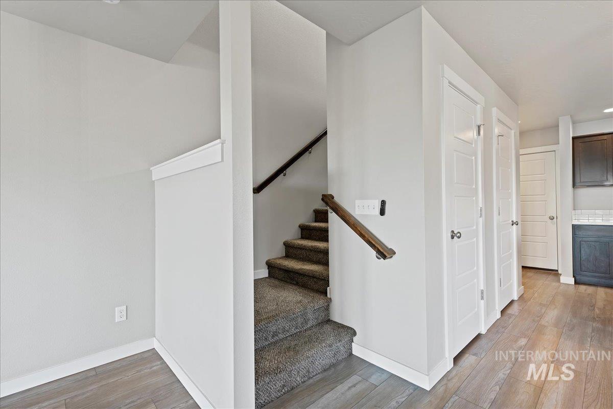 Stairway featuring wood finished floors and recessed lighting