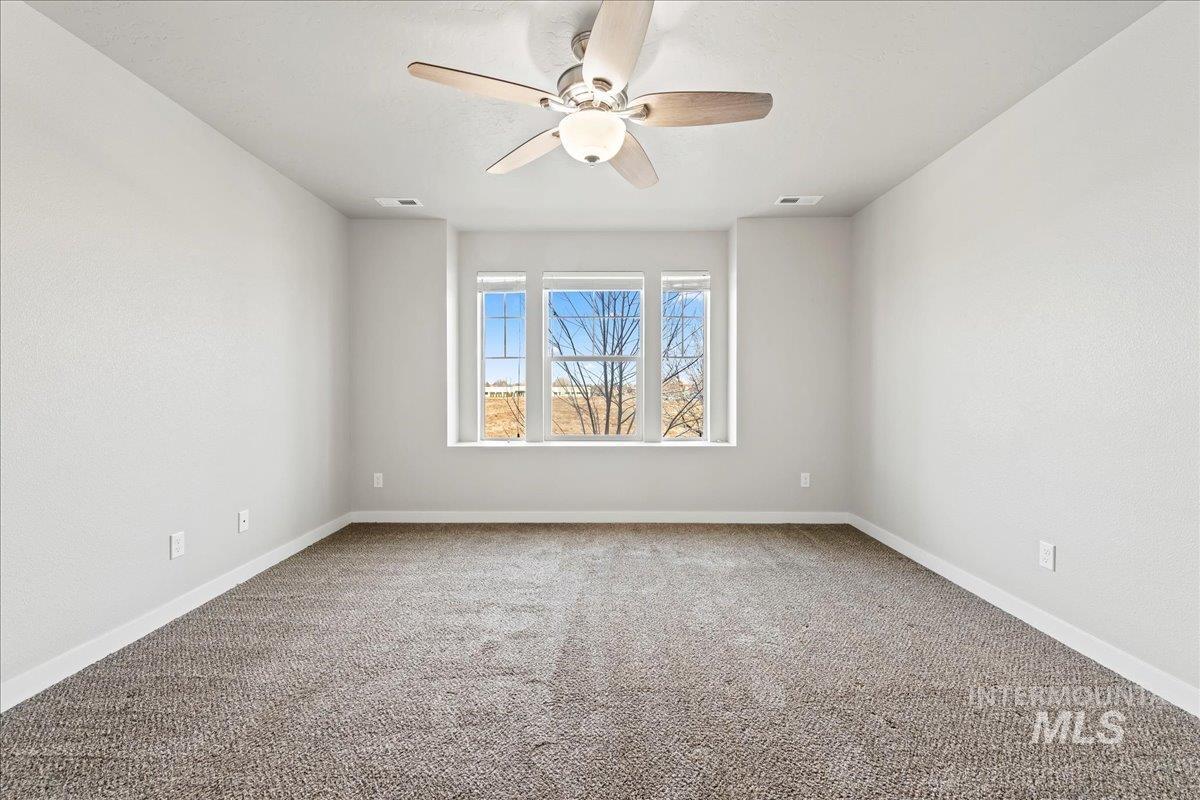 Unfurnished room with light carpet and a ceiling fan