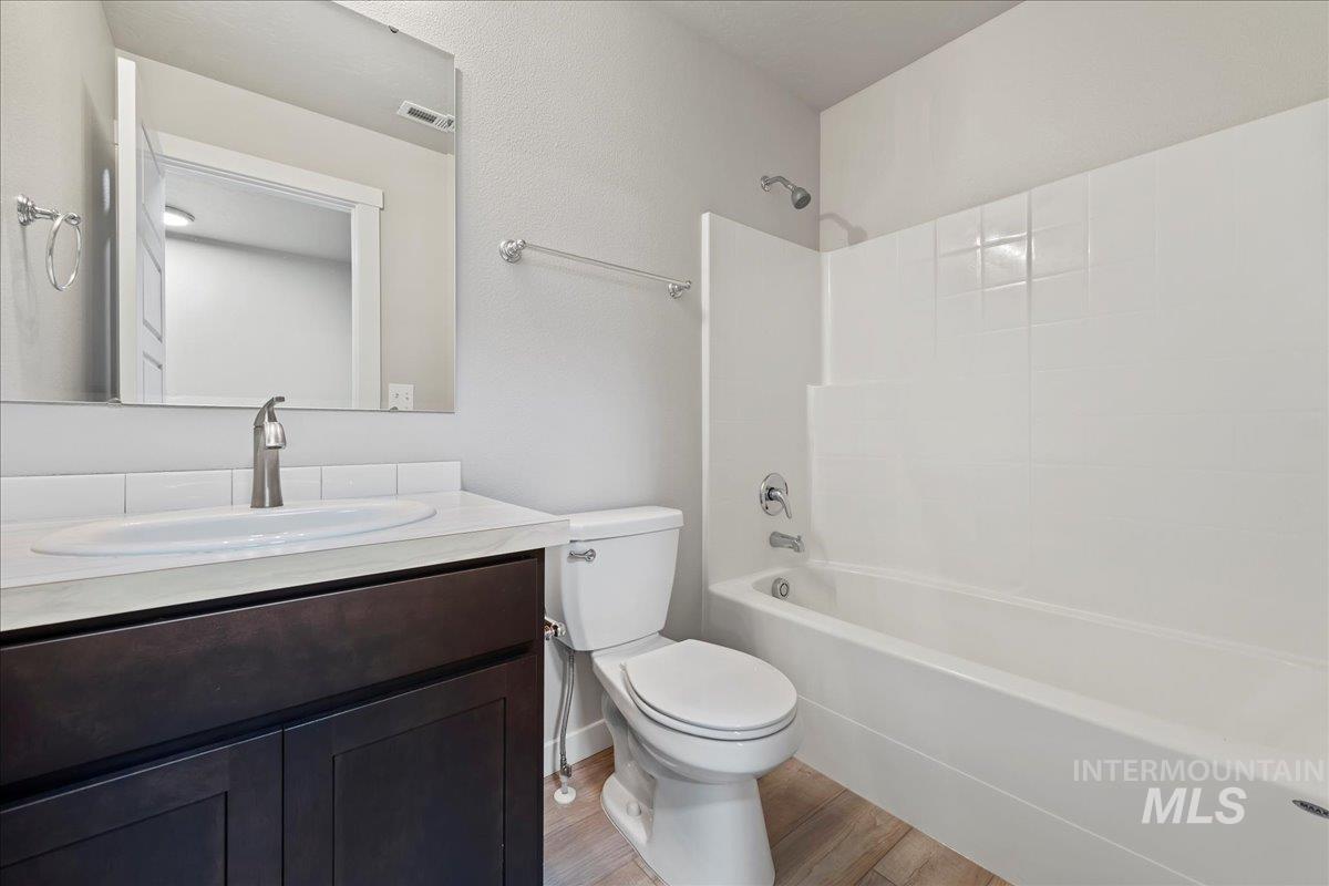 Full bath featuring vanity, shower / washtub combination, and light wood-style floors