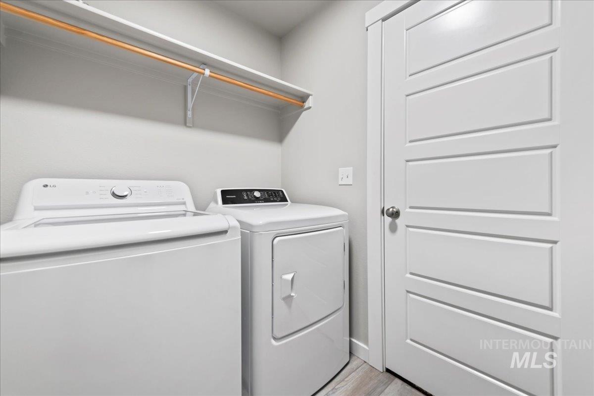 Laundry room with independent washer and dryer and light wood finished floors