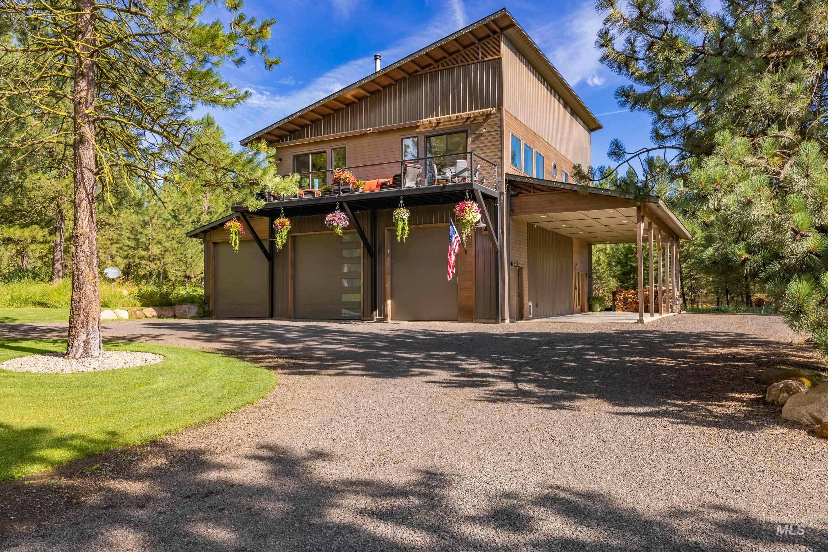 View of property exterior featuring driveway, a garage, a balcony, and a carport