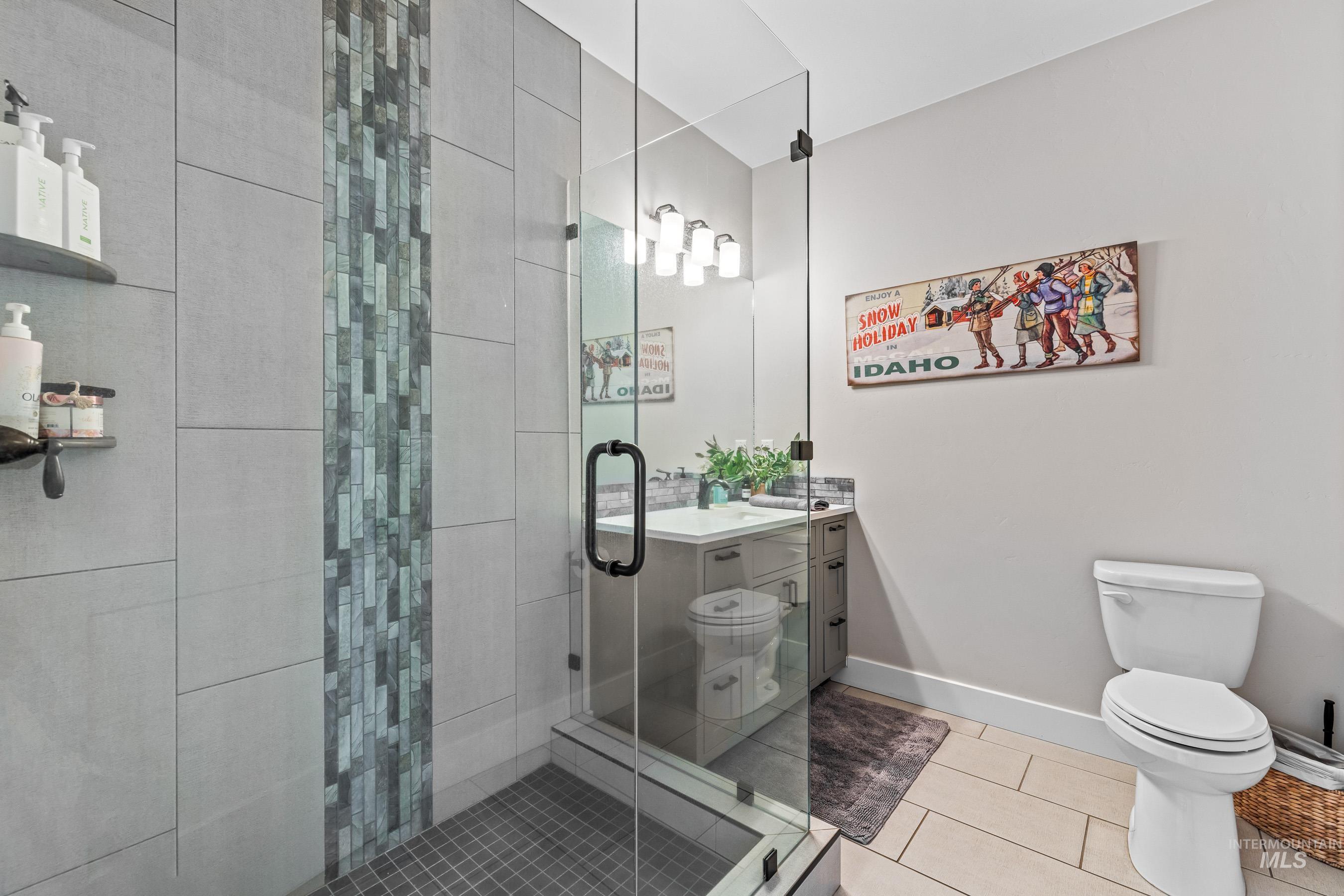Full bathroom featuring vanity, a shower stall, and tile patterned flooring