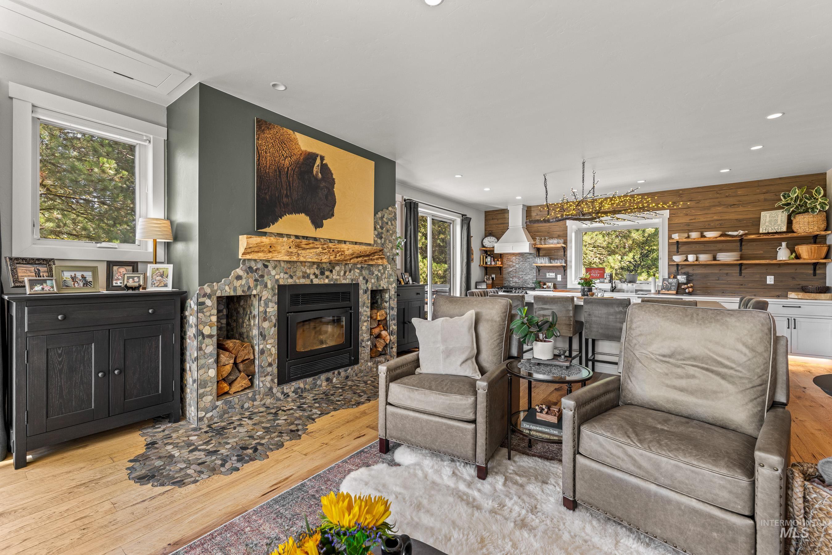 Living area featuring light wood-style floors, a stone fireplace, and recessed lighting