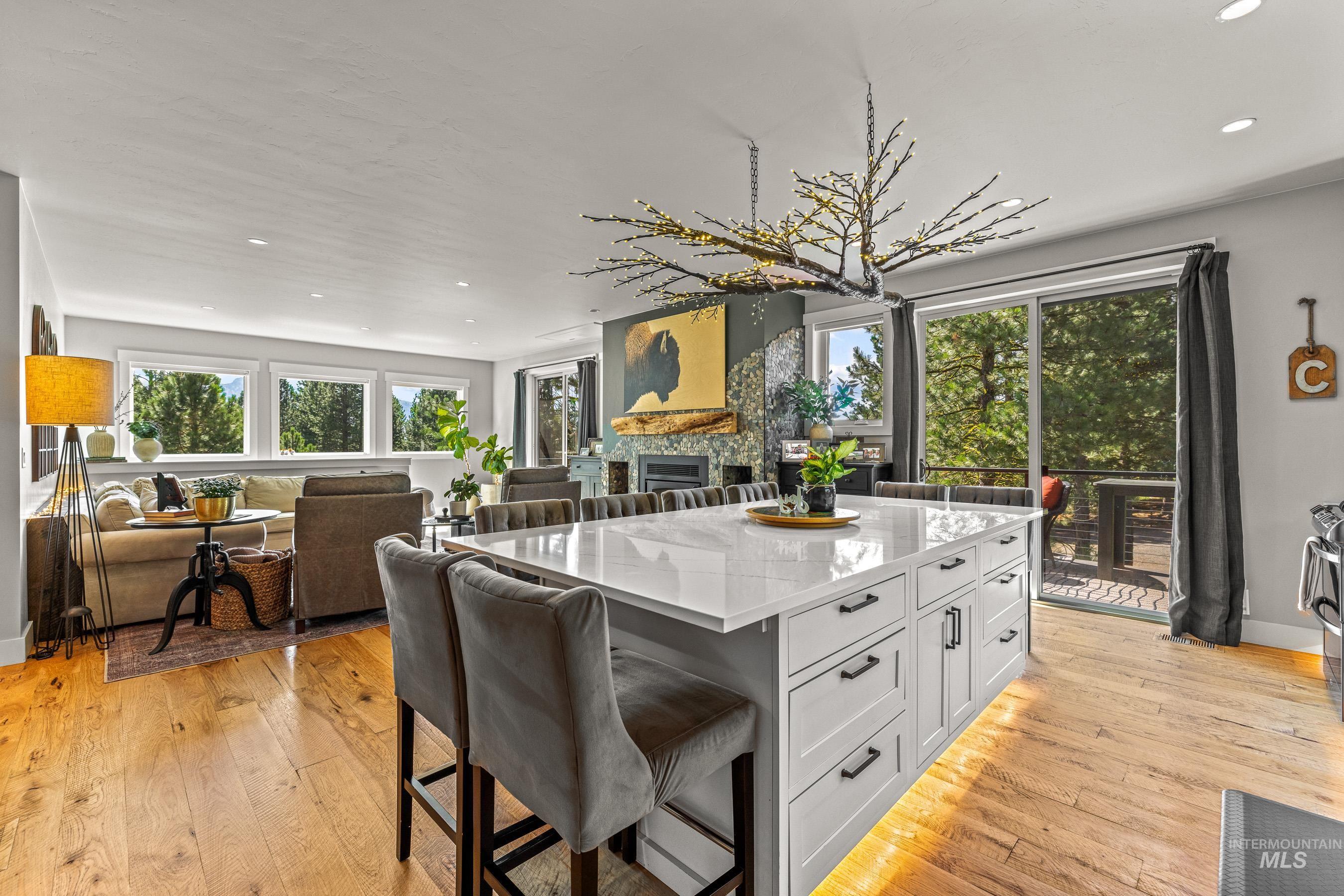 Kitchen with a kitchen island, light stone counters, a kitchen breakfast bar, recessed lighting, and open floor plan