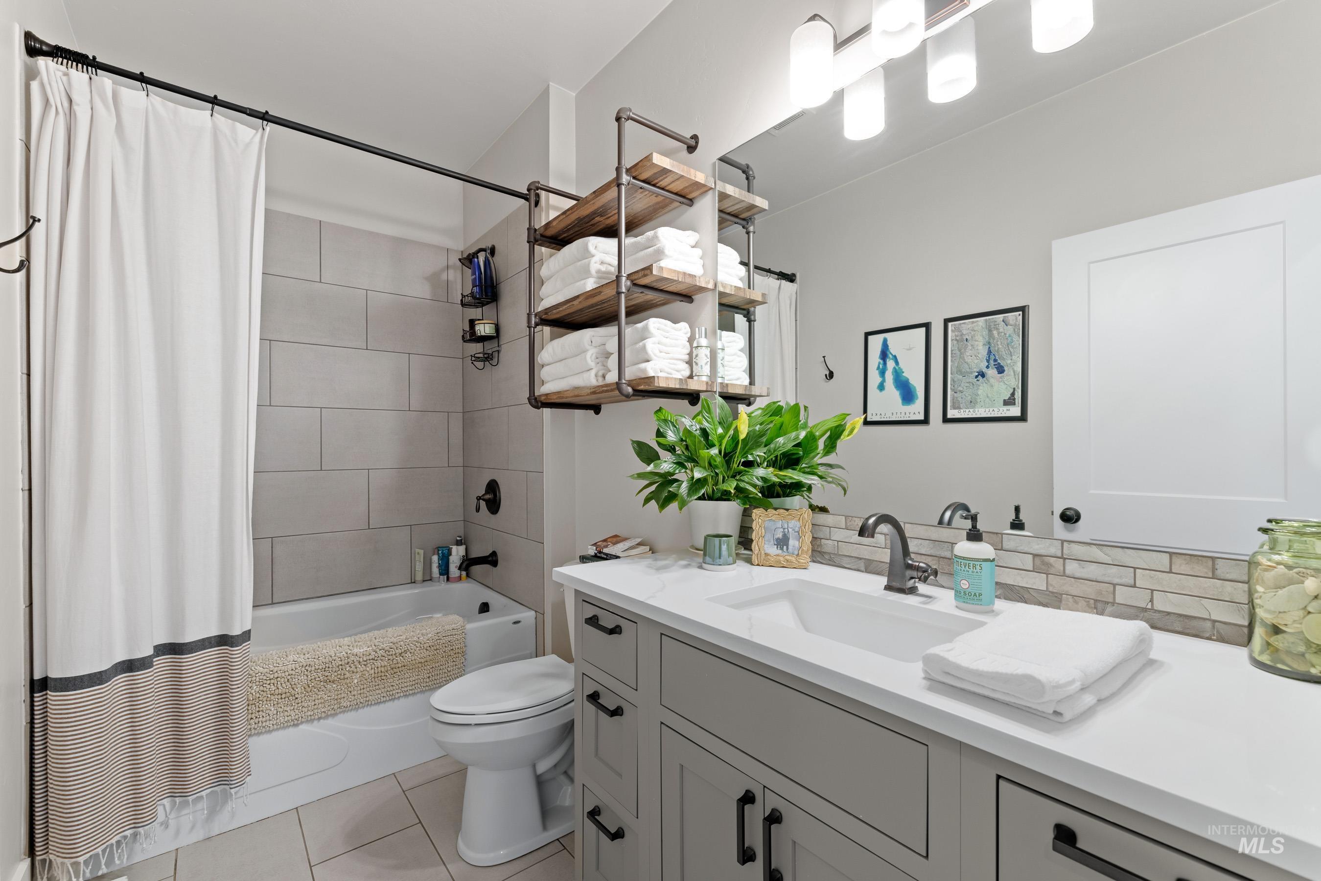 Bathroom featuring shower / tub combo, vanity, and light tile patterned flooring