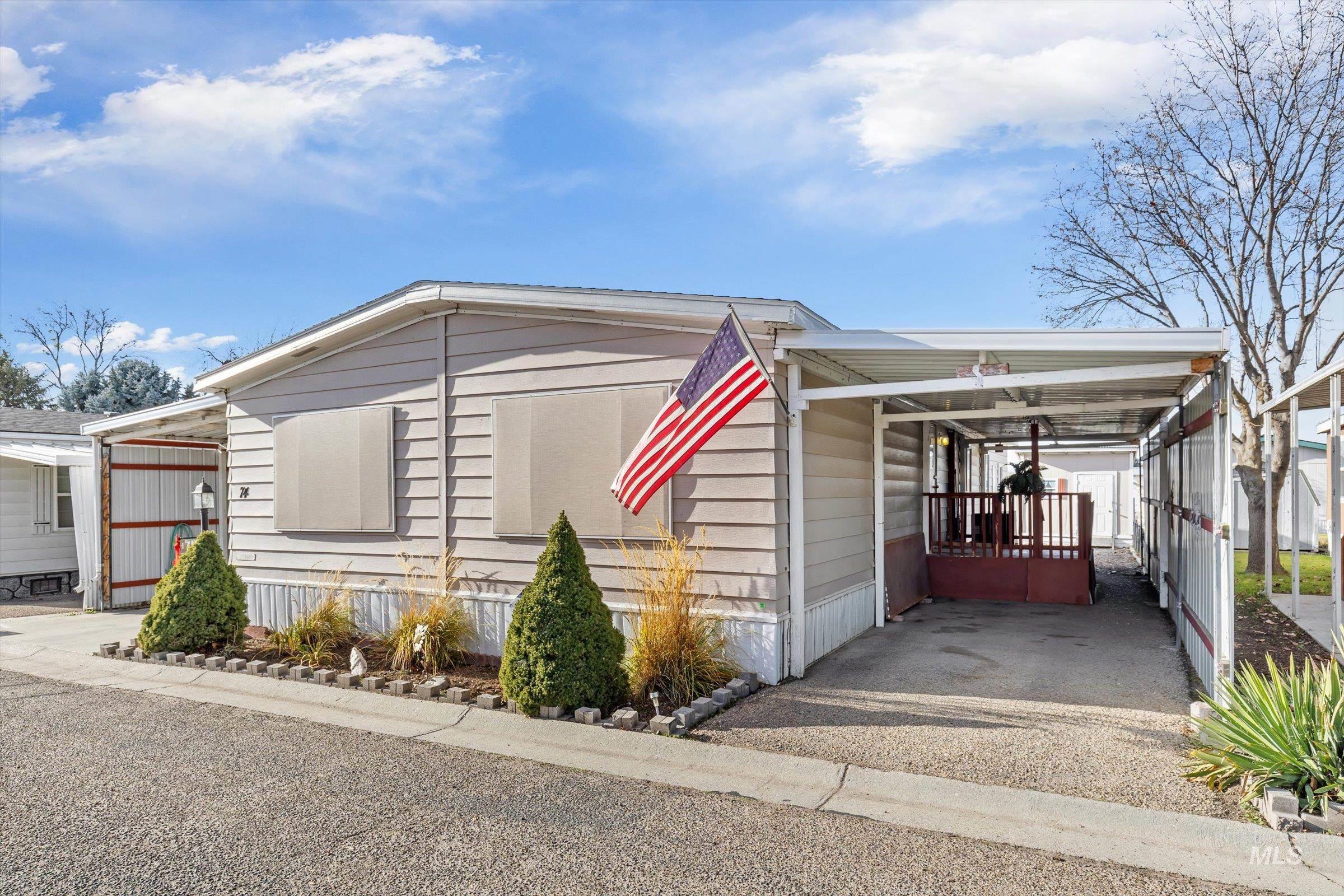 Manufactured / mobile home featuring an attached carport and driveway