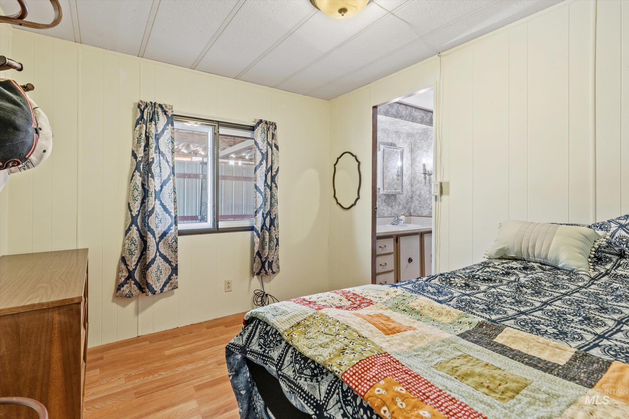 Bedroom with wood finished floors and wood walls