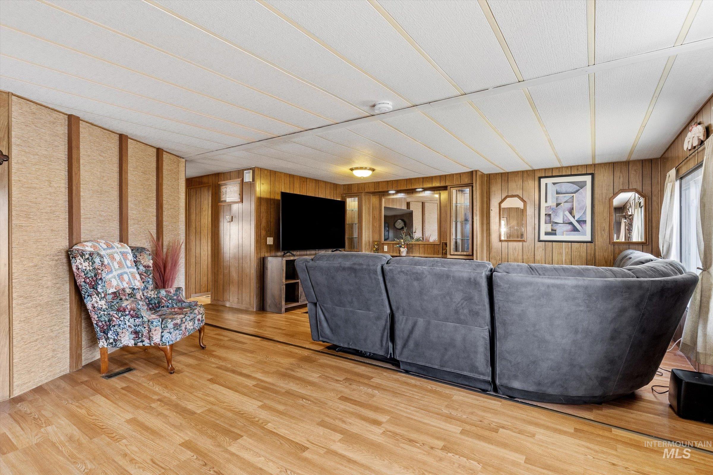 Living area with wood finished floors and wood walls