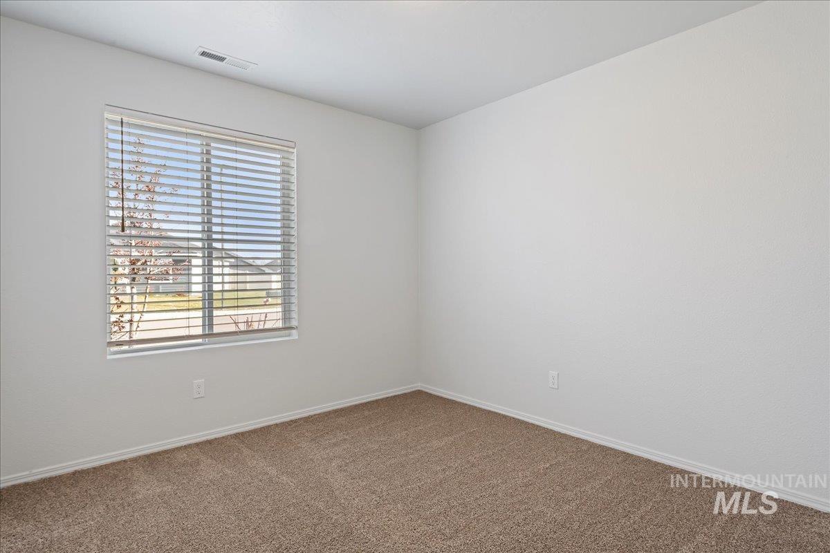 Spare room featuring carpet floors and baseboards