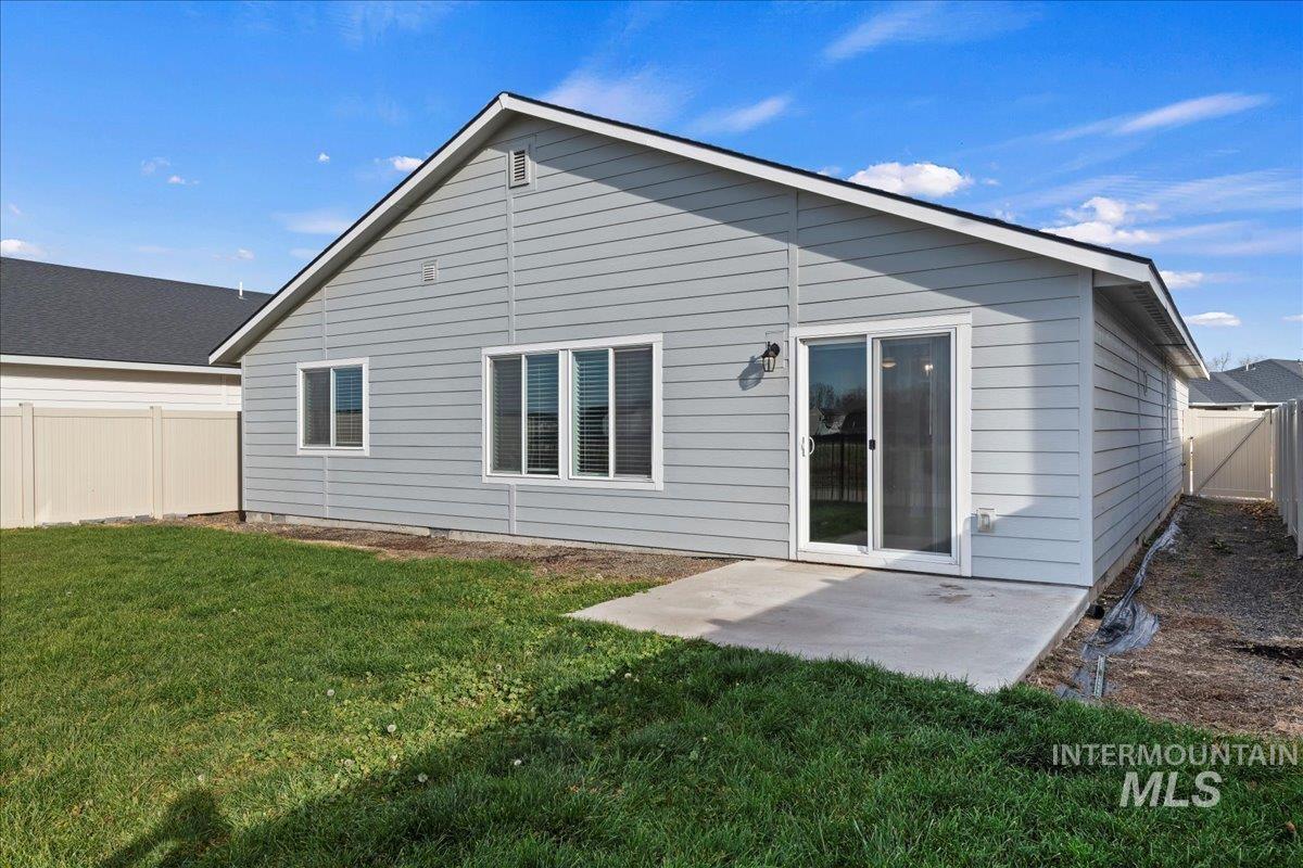Back of house with a fenced backyard and a patio area