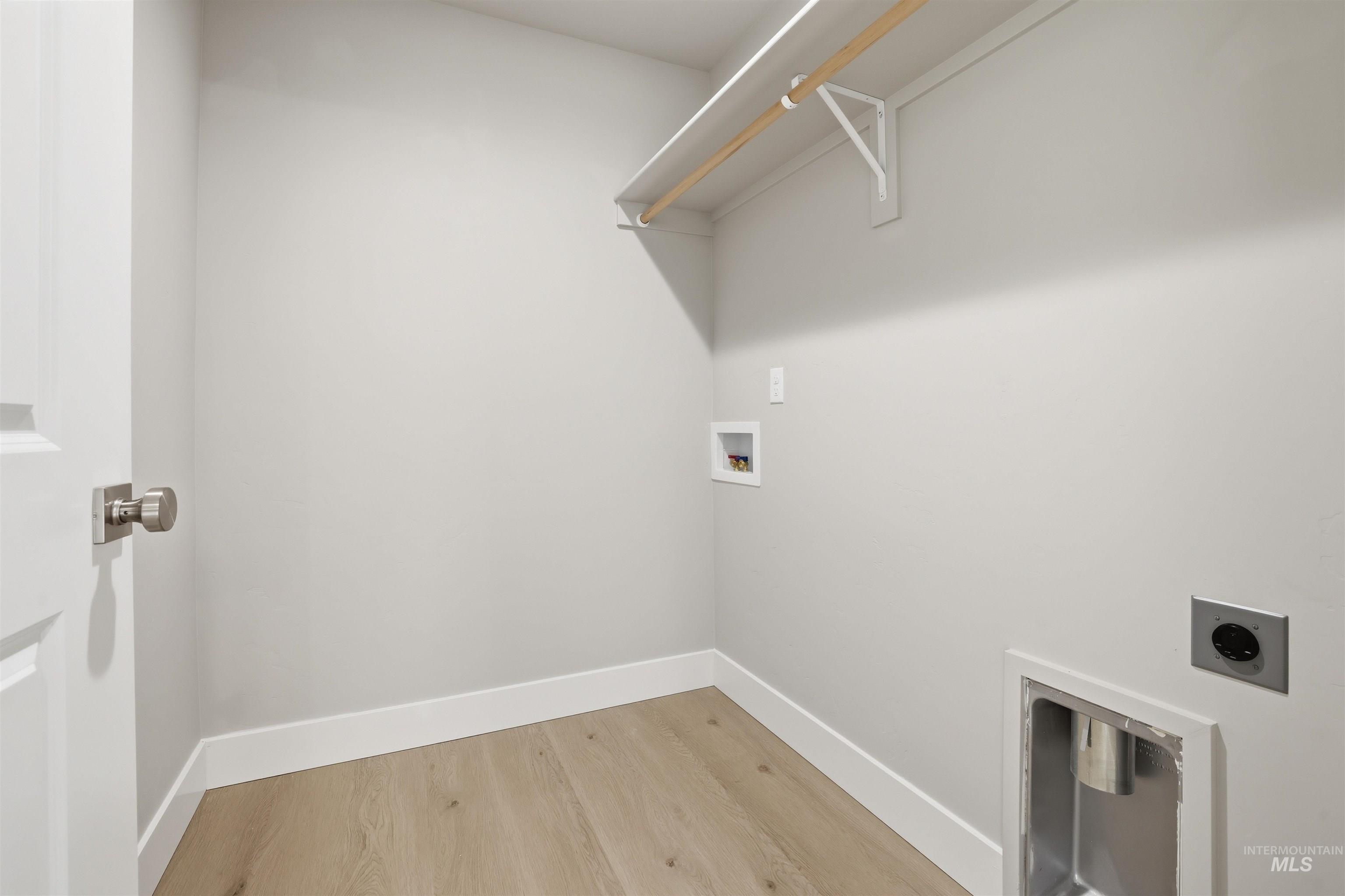 Washroom with hookup for a washing machine, light wood-style floors, and electric dryer hookup