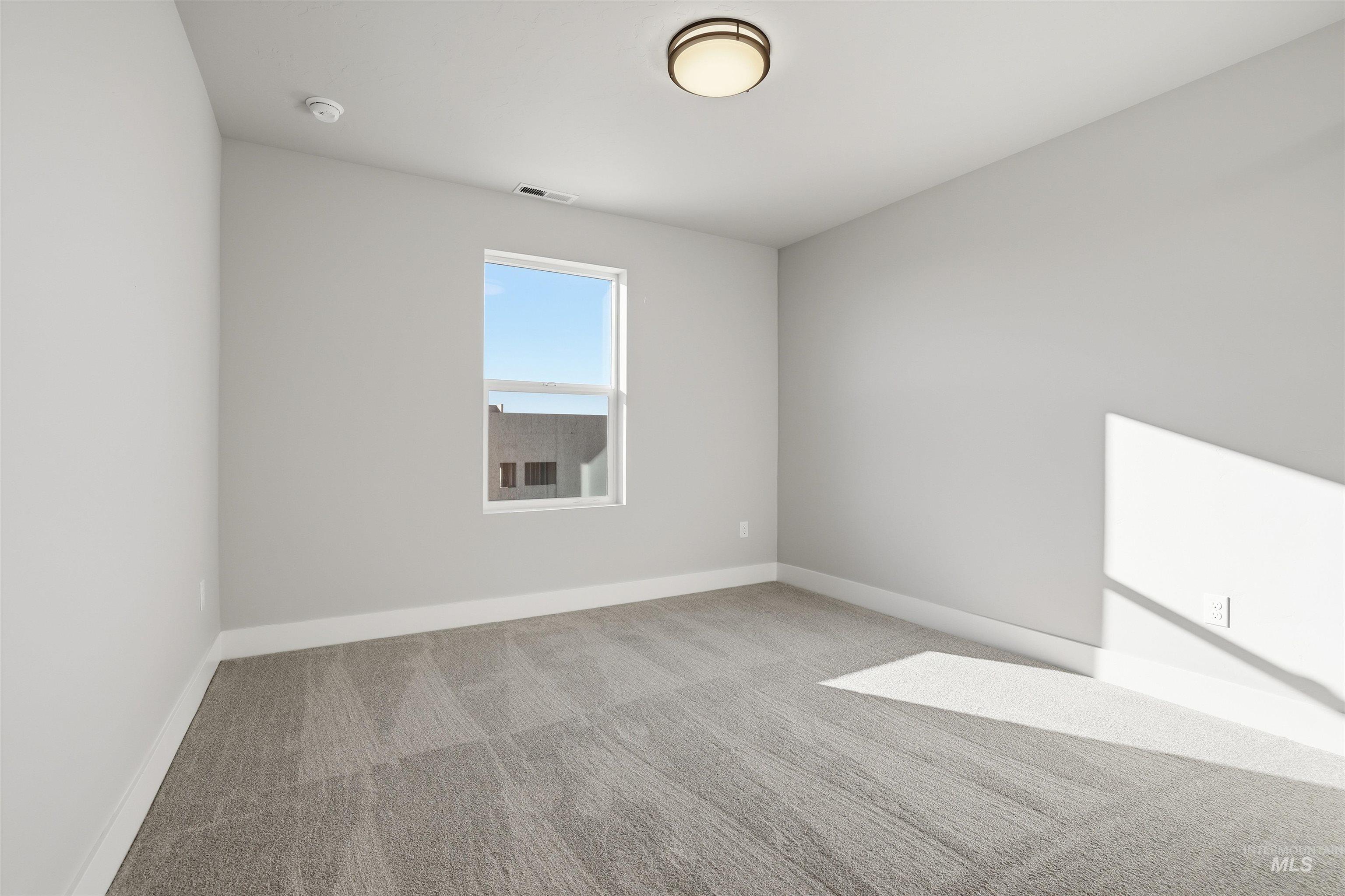 Empty room featuring carpet and baseboards