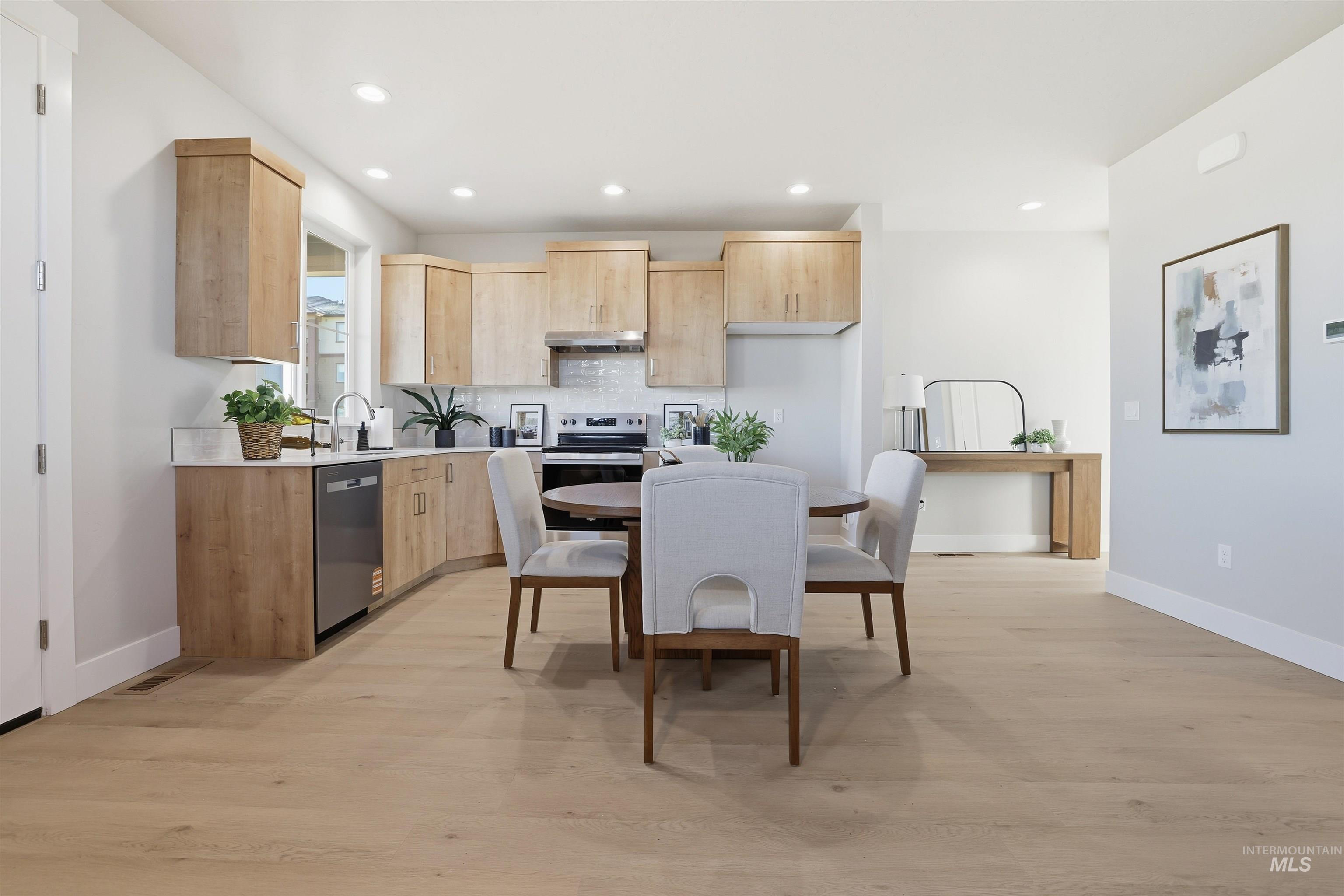 Kitchen featuring light brown cabinetry, stainless steel appliances, recessed lighting, light wood-style floors, and modern cabinets