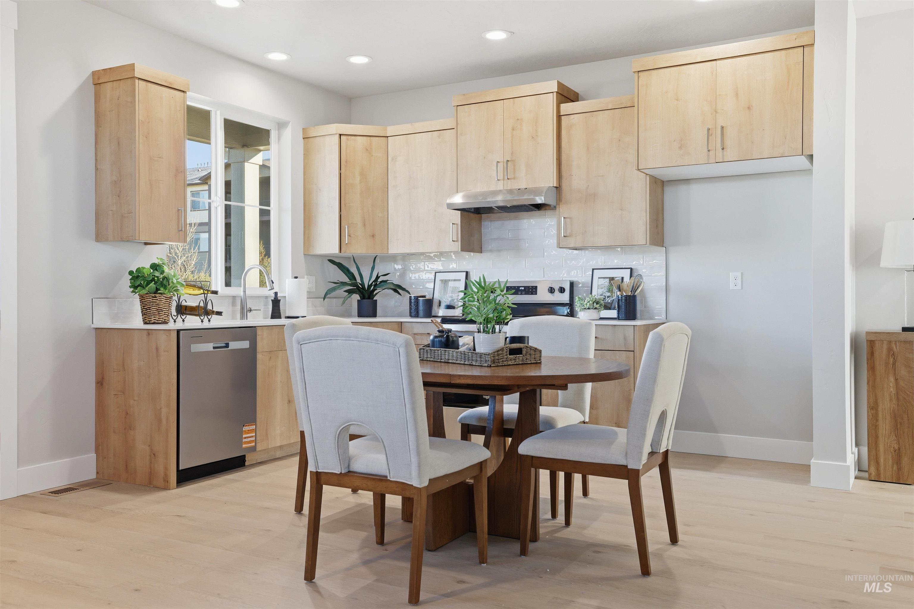 Kitchen with light brown cabinetry, modern cabinets, stainless steel dishwasher, decorative backsplash, and recessed lighting