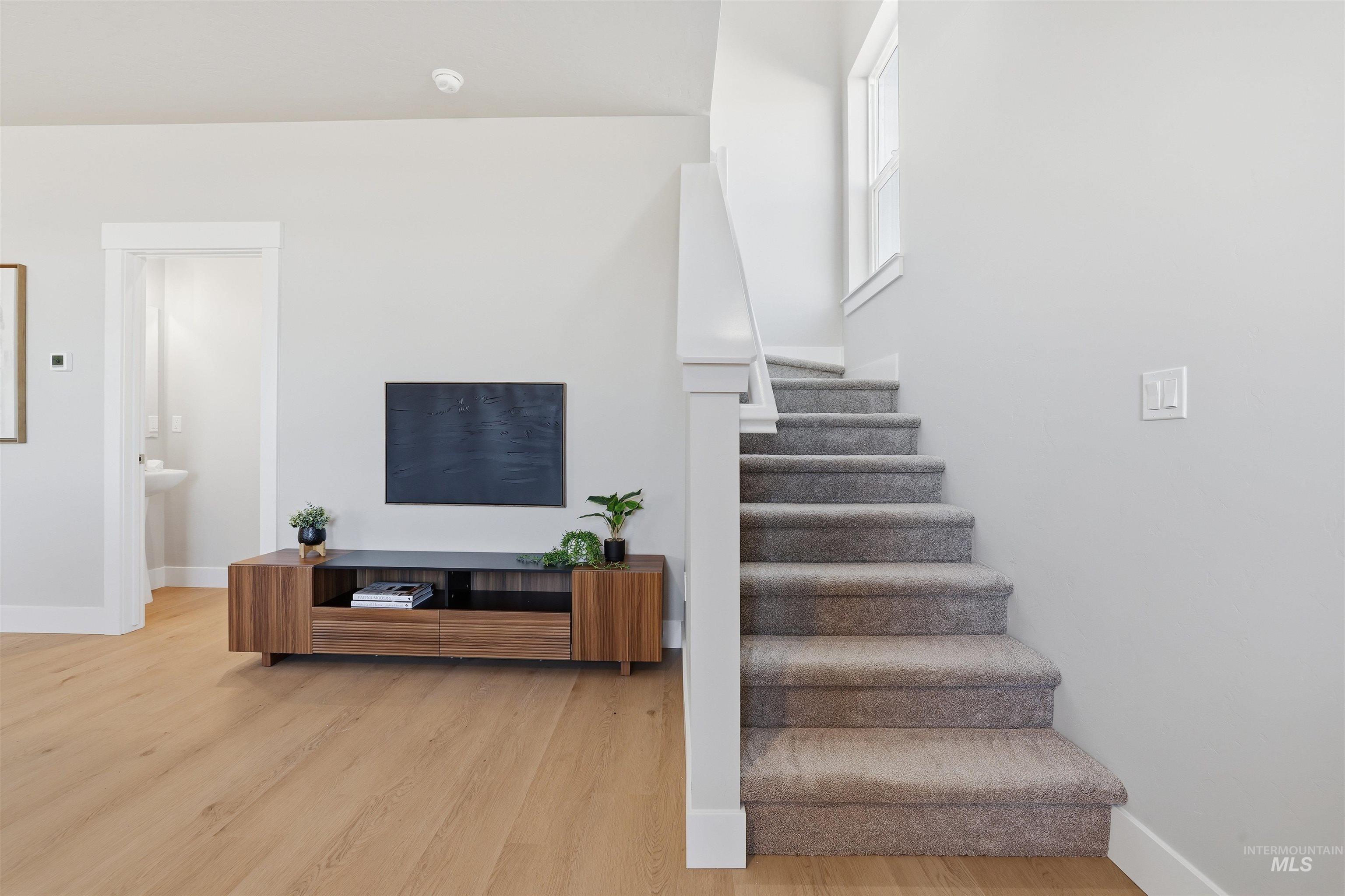 Stairway with baseboards and wood finished floors