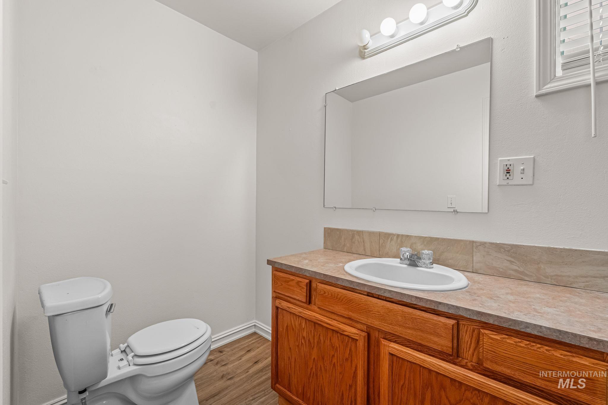 Half bath featuring vanity and light wood-type flooring