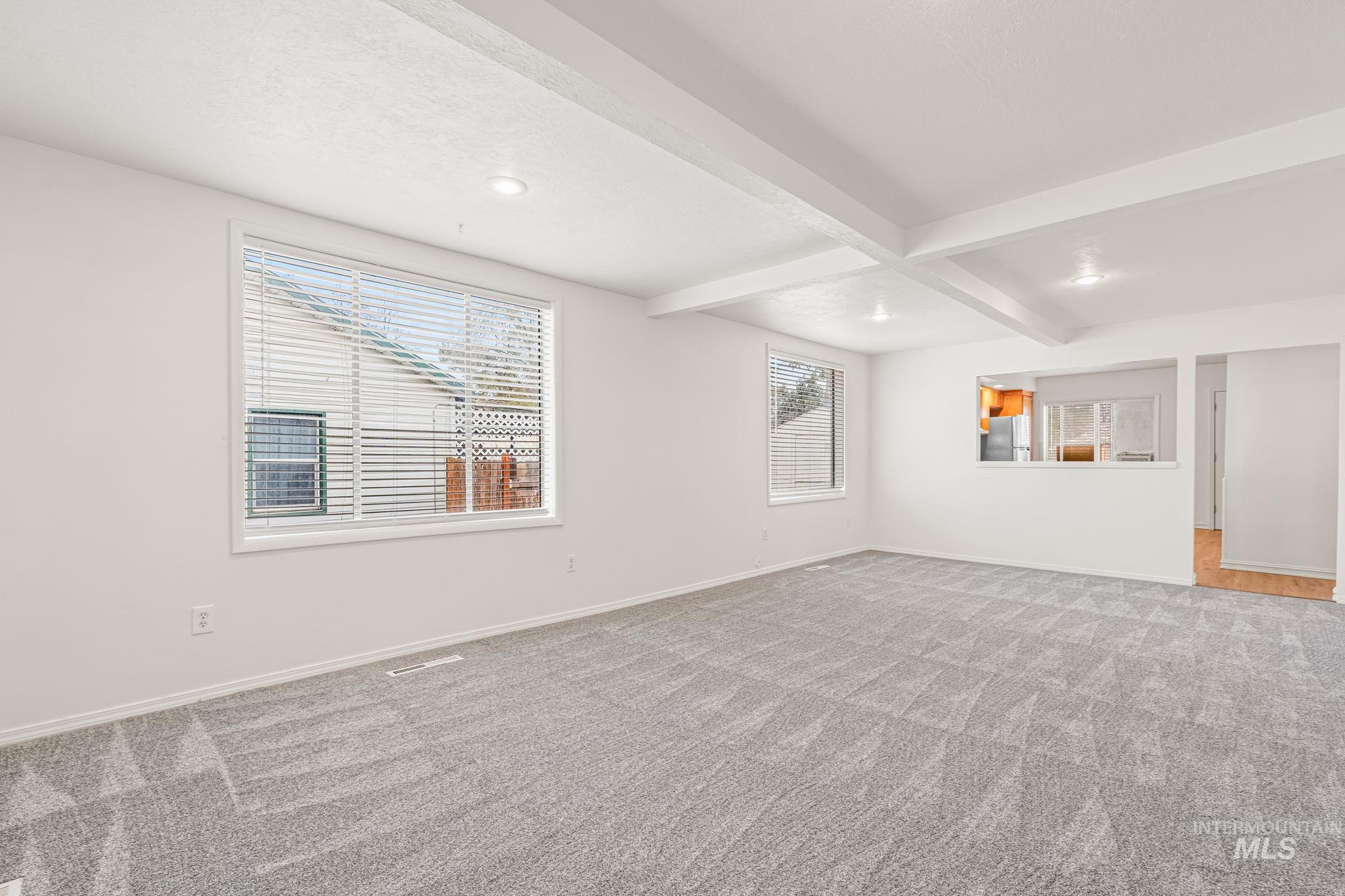 Unfurnished room featuring beamed ceiling, recessed lighting, and light carpet