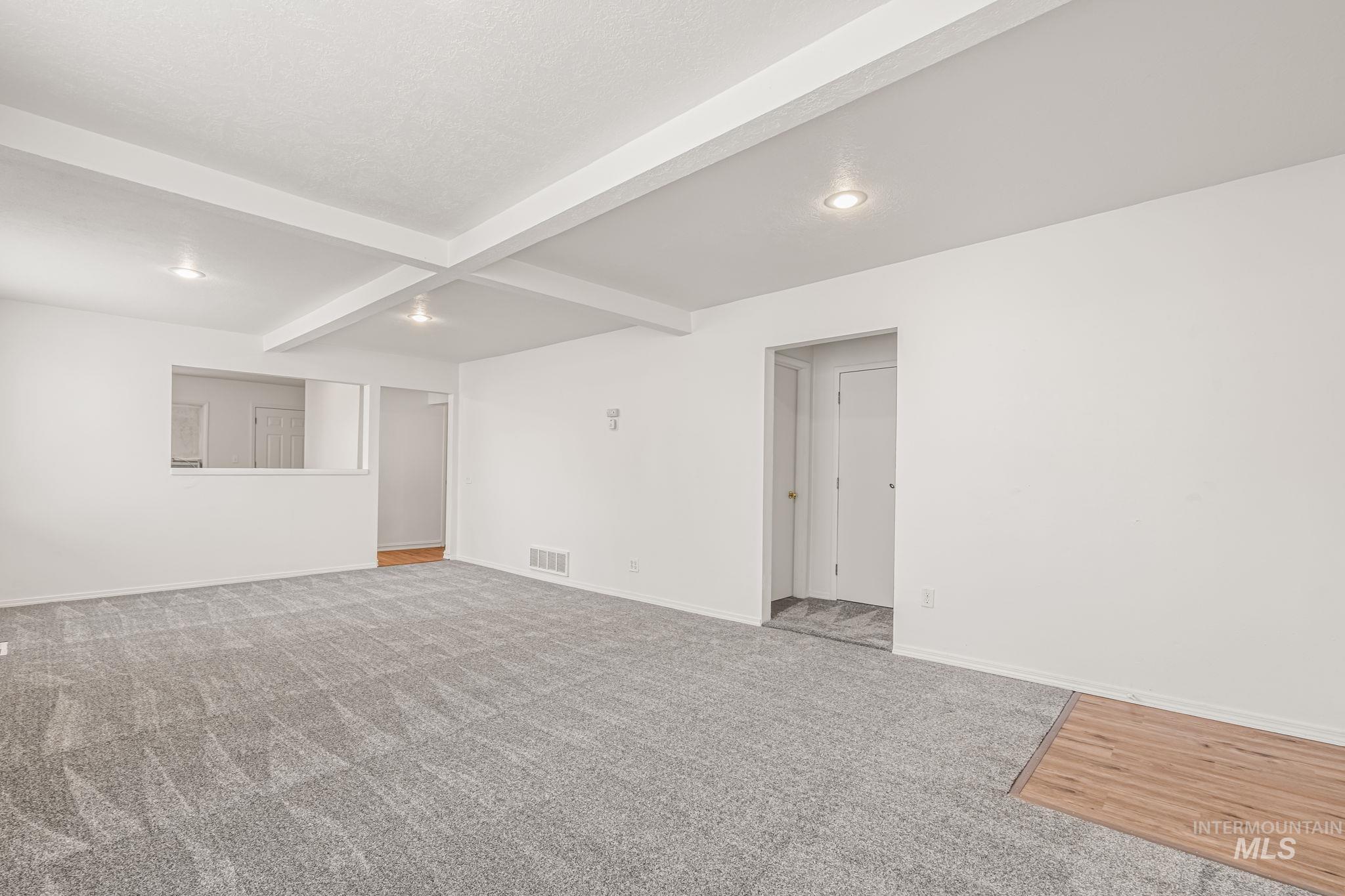 Carpeted spare room featuring beamed ceiling and recessed lighting