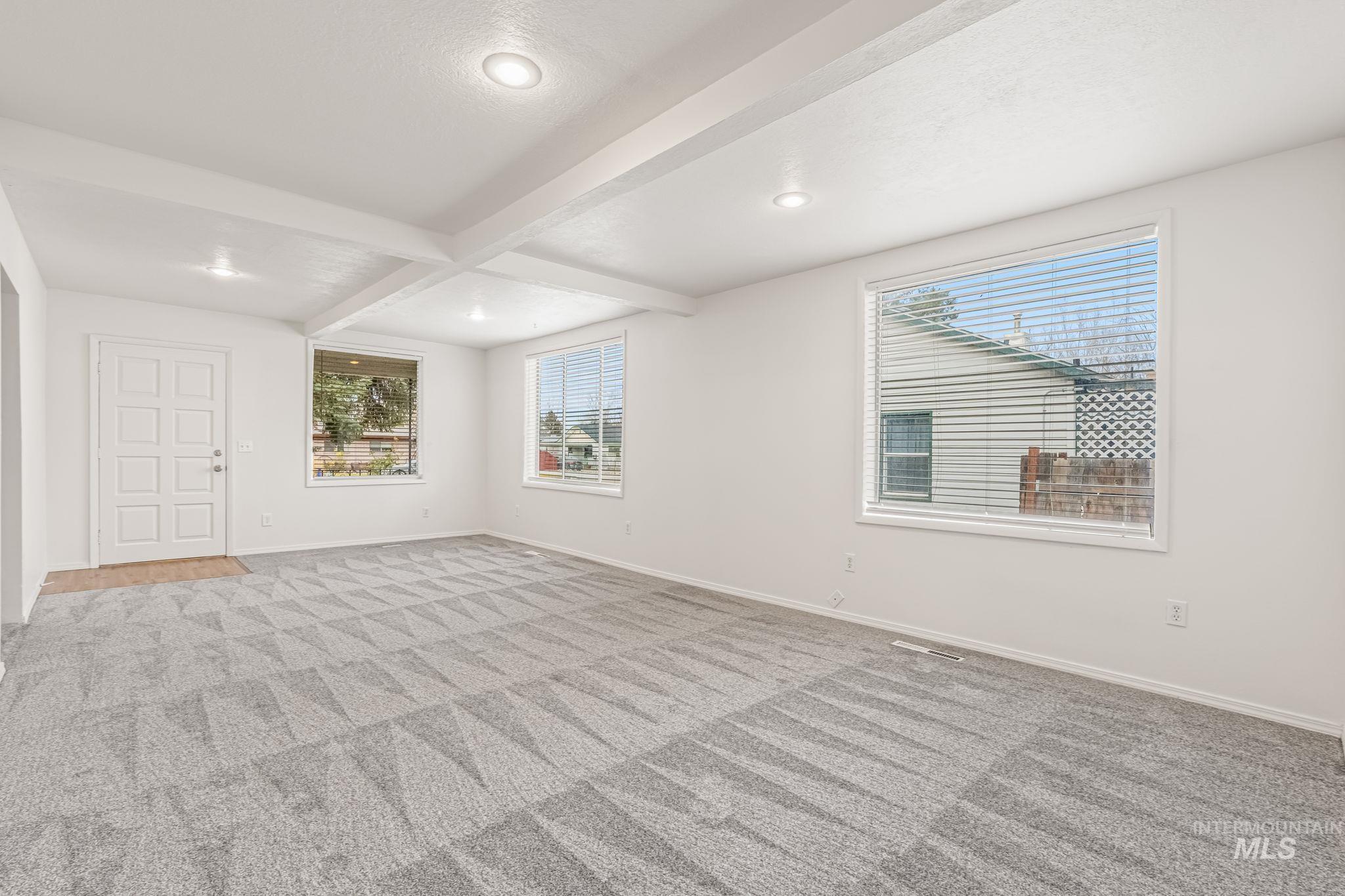 Empty room featuring beam ceiling, recessed lighting, light colored carpet, and coffered ceiling