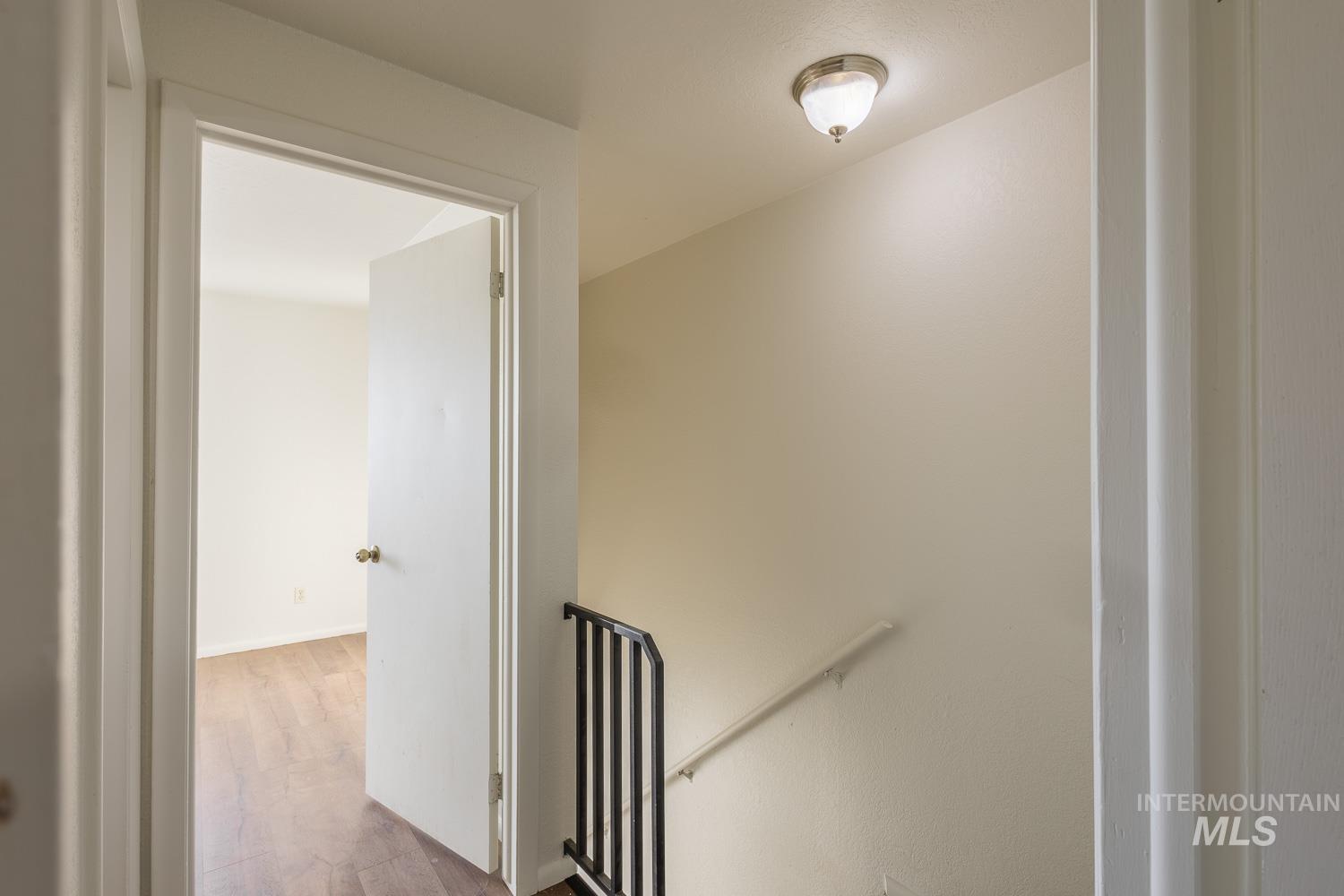 Hallway with an upstairs landing and wood finished floors
