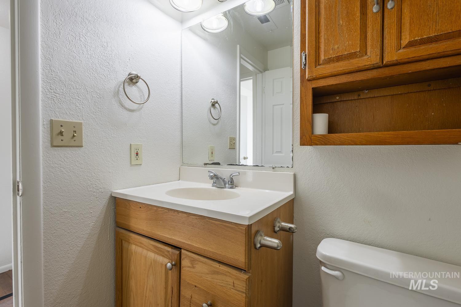 Bathroom featuring a textured wall and vanity