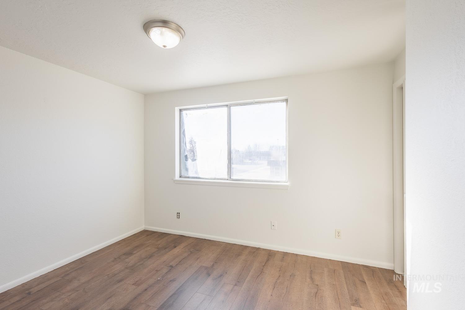 Unfurnished room with baseboards and wood-type flooring