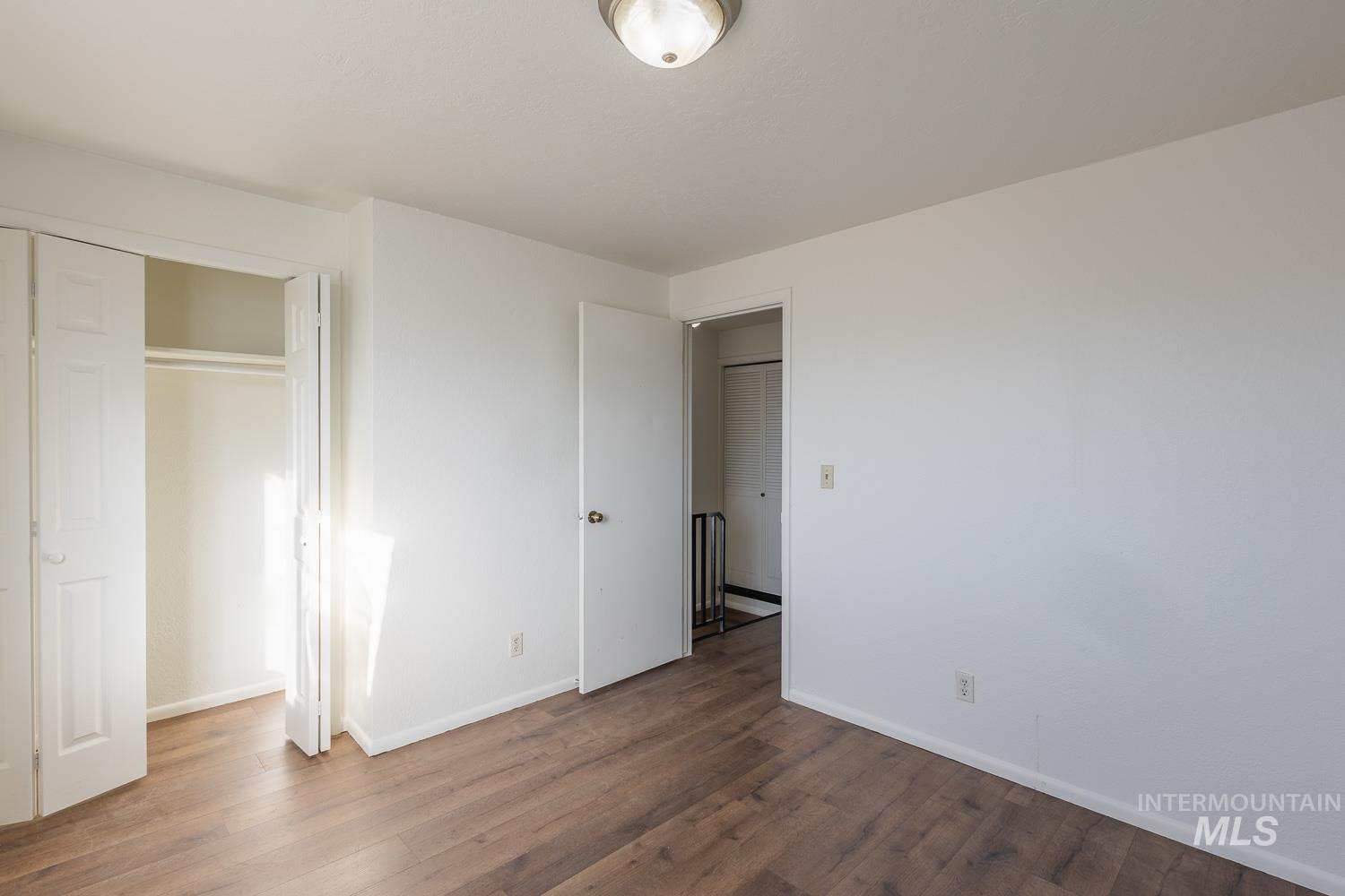 Unfurnished bedroom featuring wood finished floors and a closet
