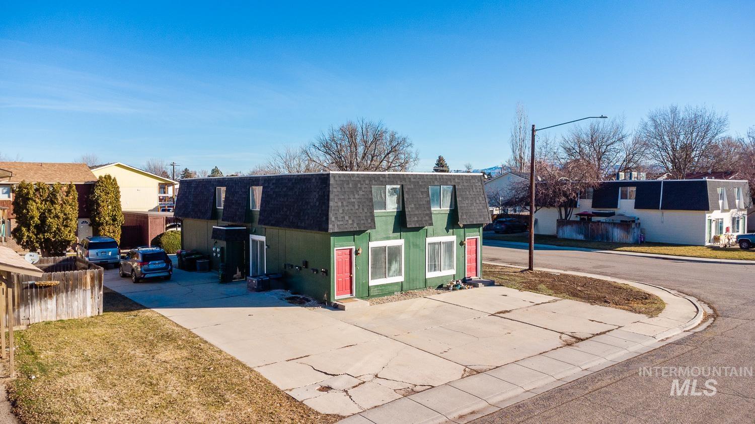 View of front of house with a shingled roof, mansard roof, concrete driveway, and a residential view