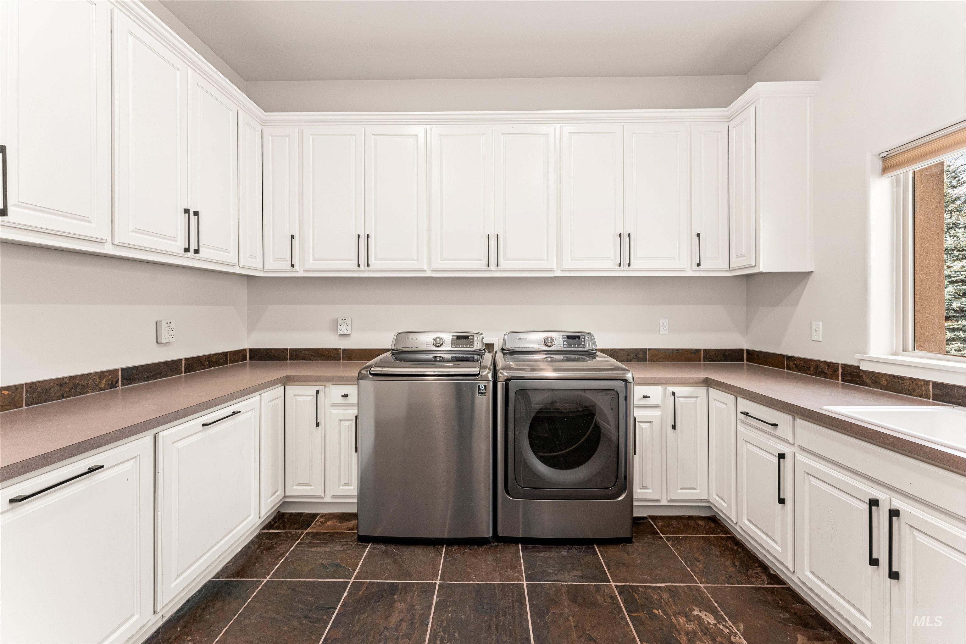 Washroom featuring washer and dryer and cabinet space
